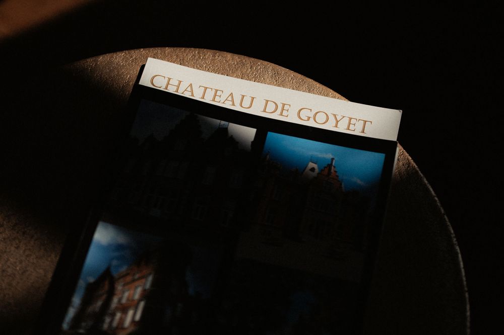 A close-up shot shows a book spine labeled Chateau De Coyel with dramatic lighting and shadows.
