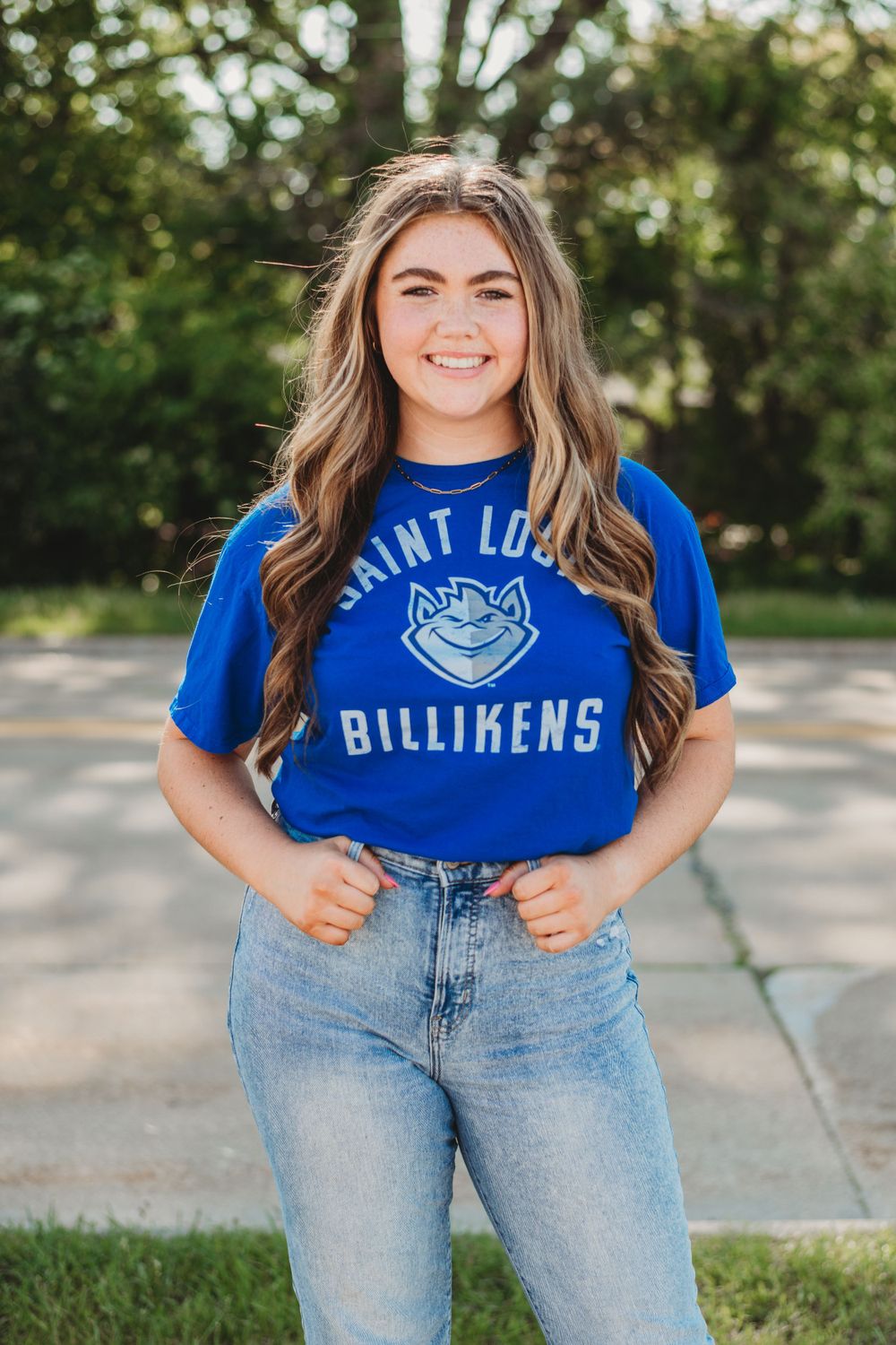 Casual portraits wearing a Saint Louis Billikens t-shirt and jeans in an outdoor setting.