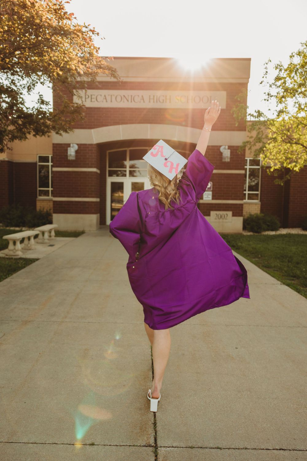 Sunset graduation photos in front of Pecatonica High School with flowing purple gown.
