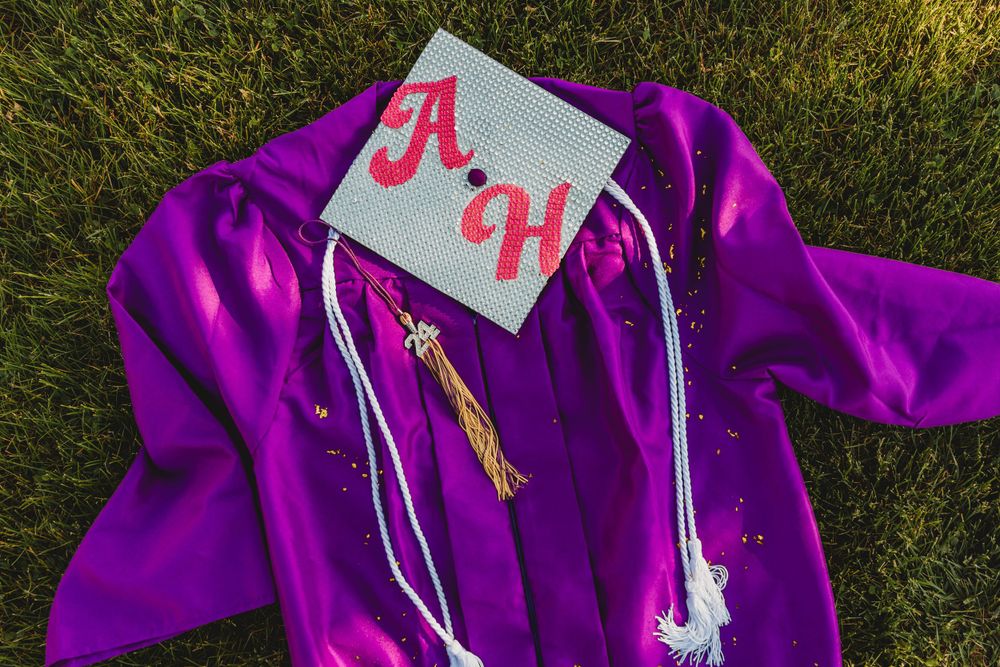 Close-up detail shots of purple graduation cap with decorative tassels on grass.