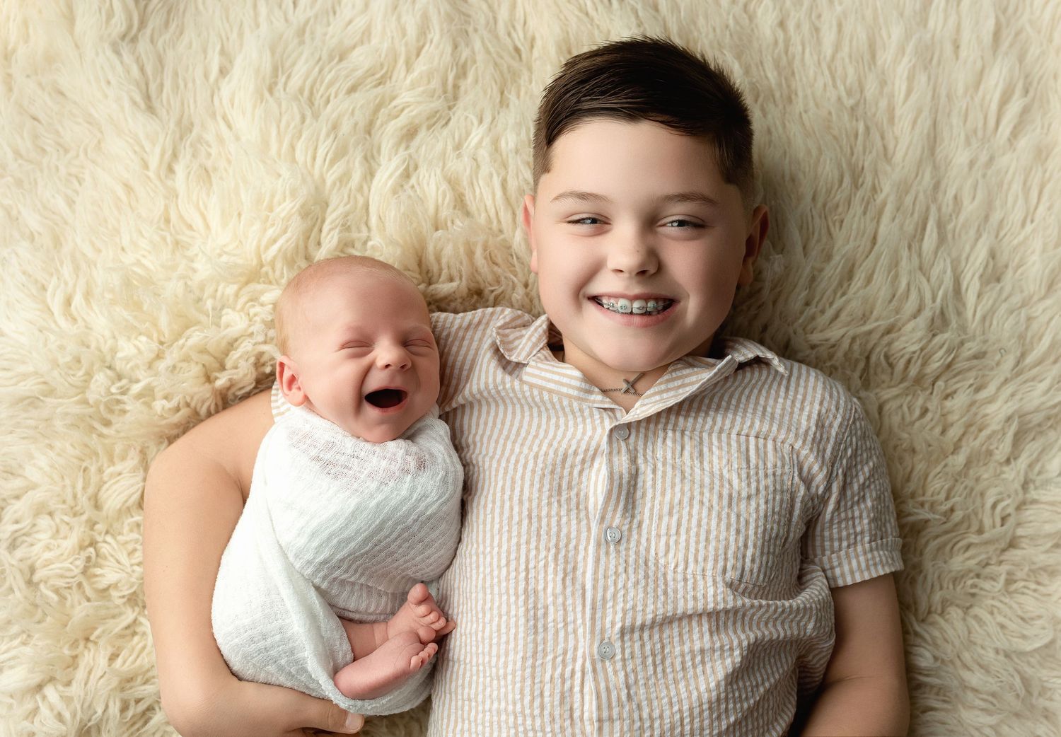 A proud brother holding his newborn baby brother. Greenville SC newborn photographer, Easley SC newborn photographer