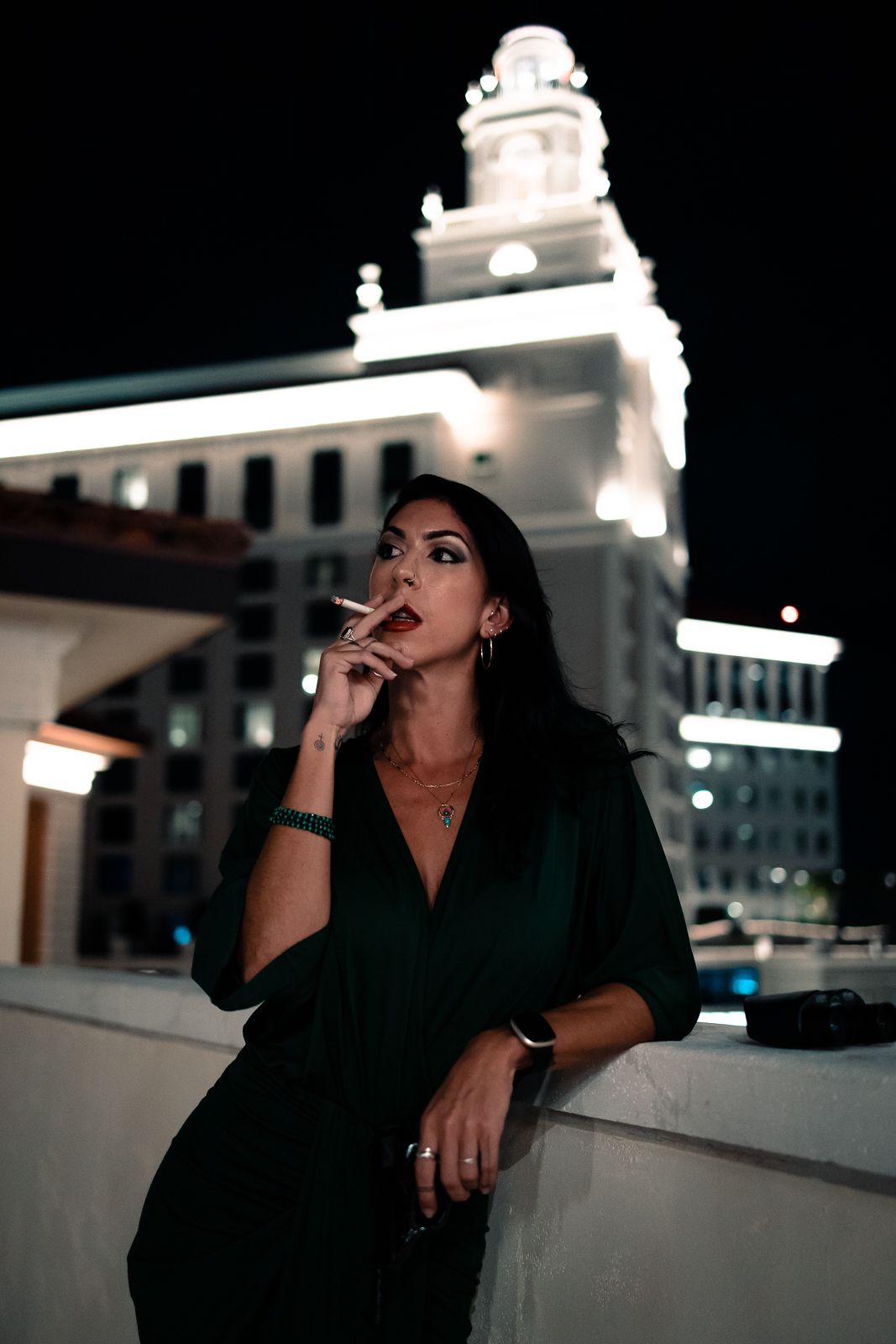 Elegant woman in black dress under city lights, cinematic lifestyle portrait, South Florida nightlife editorial photography.