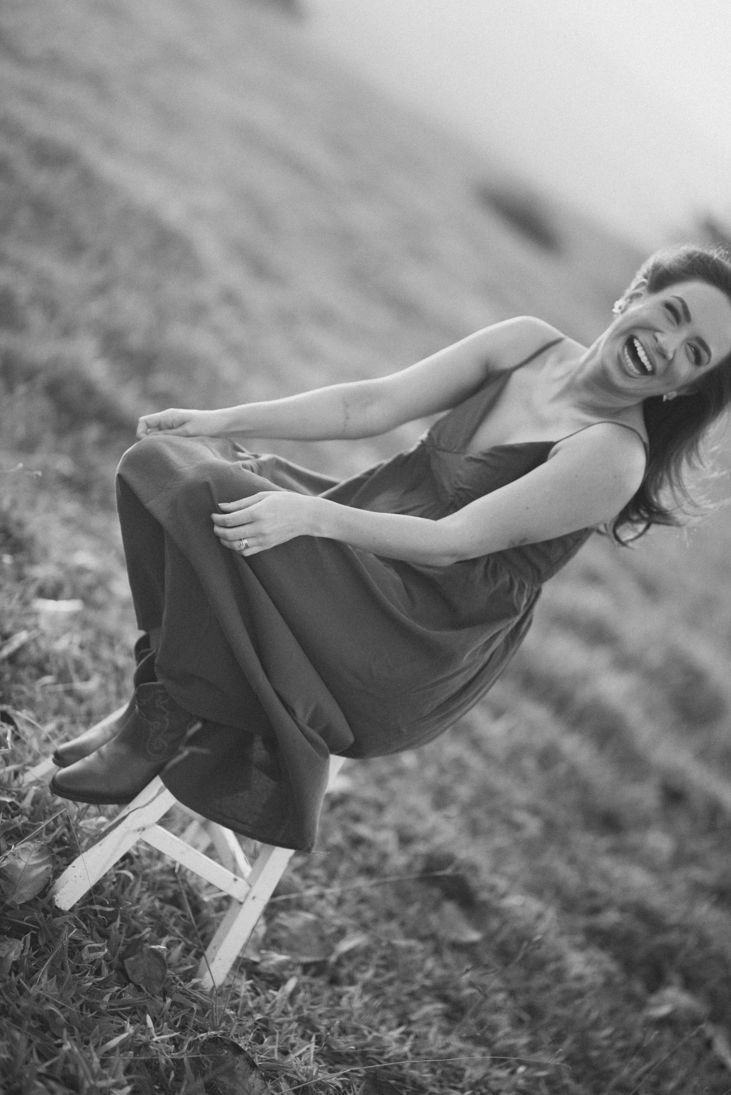 Black and white portrait of joyful moment on wooden stool outdoors.
