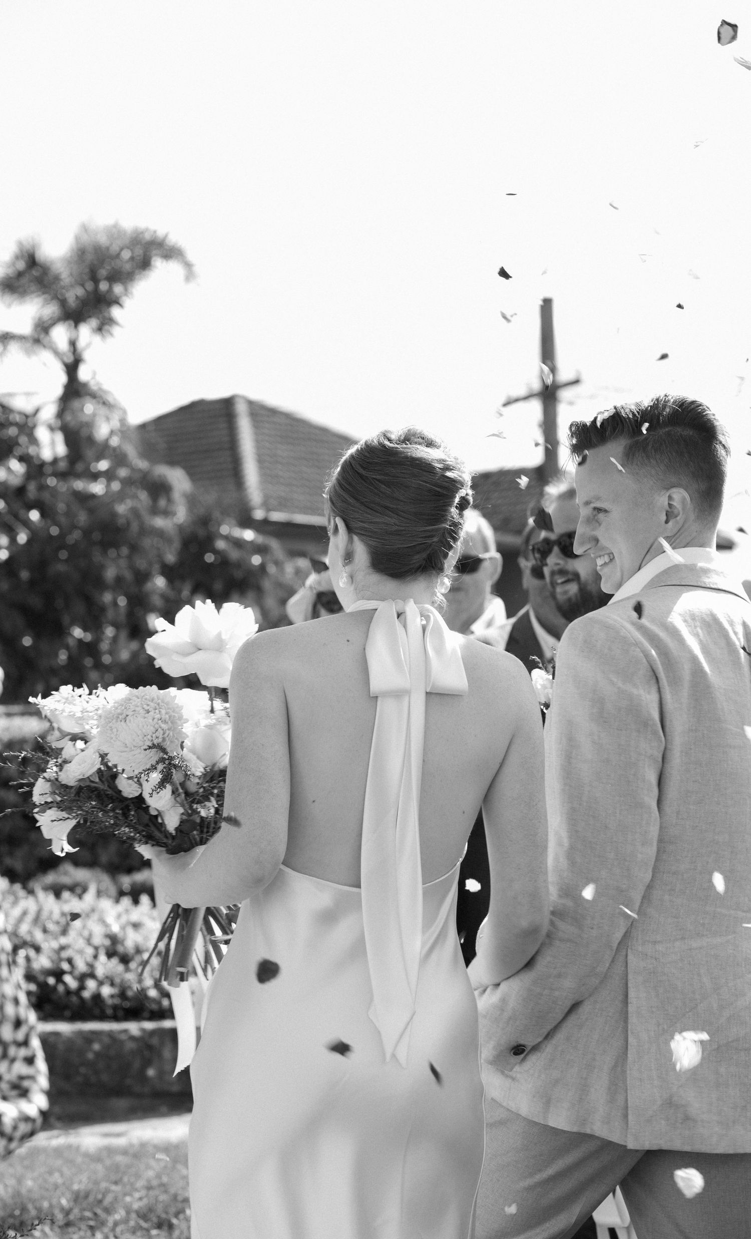 Black and white wedding photo capturing a couple during an outdoor ceremony.