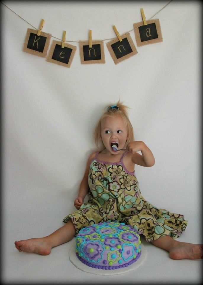 Birthday cake scene with hanging letter decorations on clothespins.