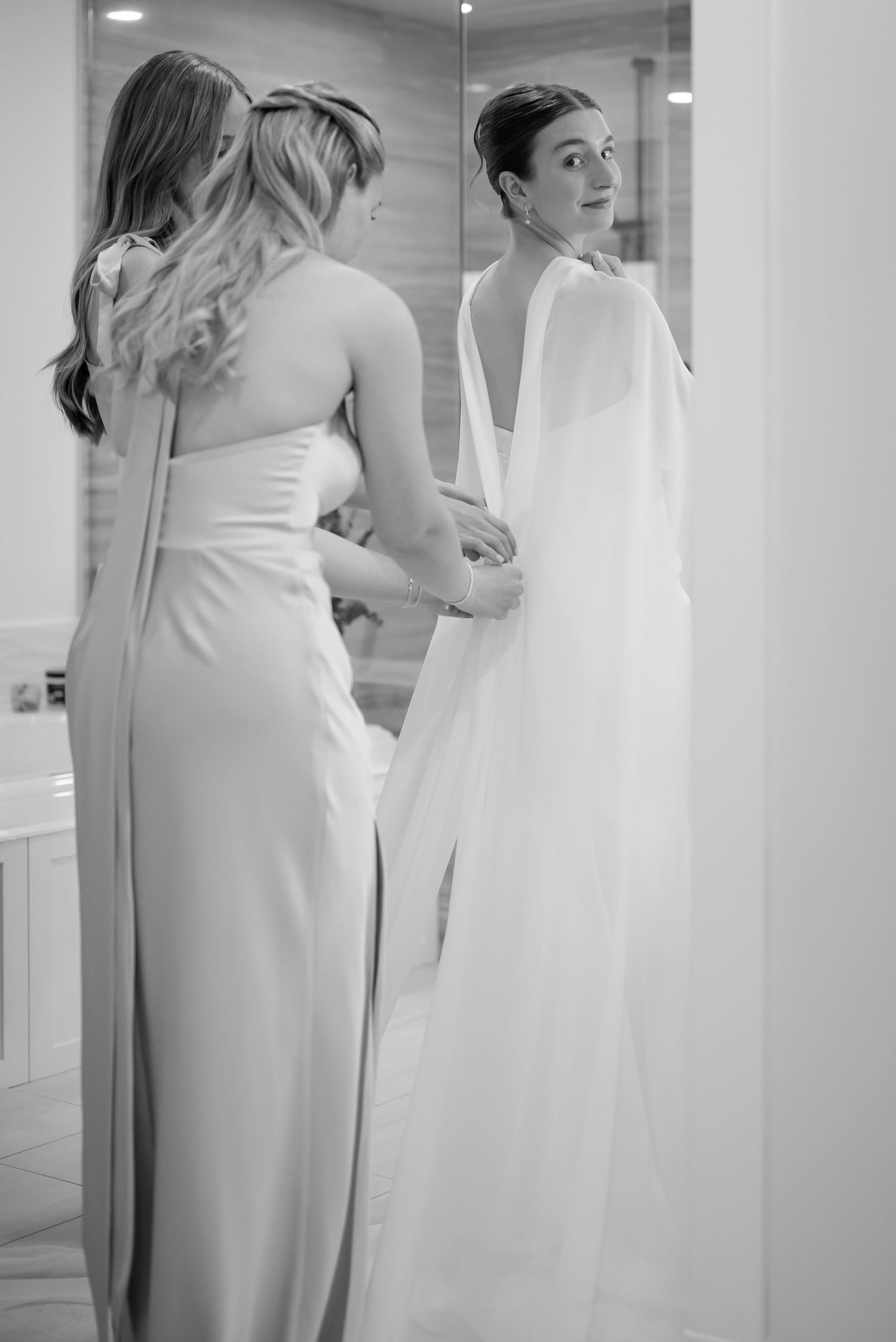 Black and white photo of bride and groom sharing a romantic kiss as he dips her, capturing classic essence.