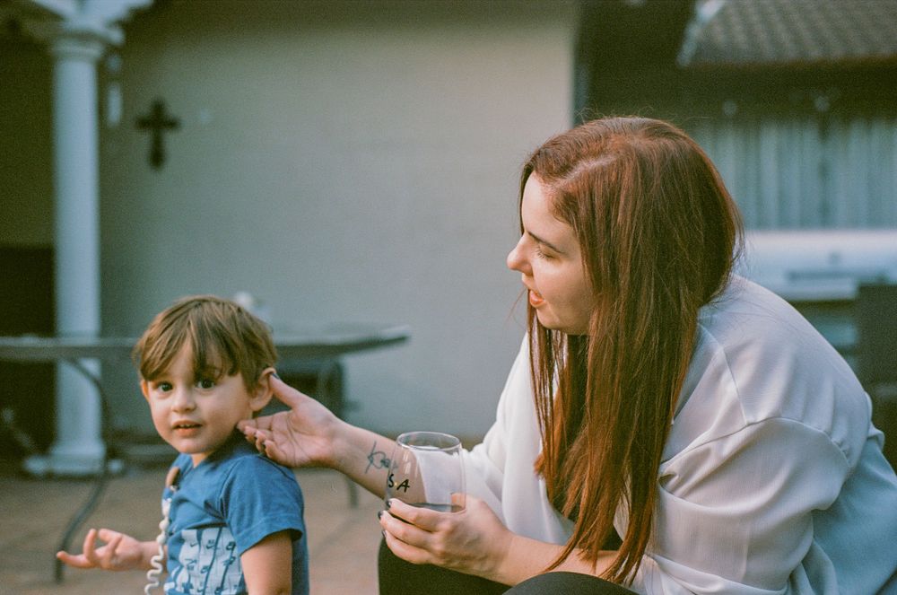 Two people sit together outdoors having an intimate conversation on a porch.