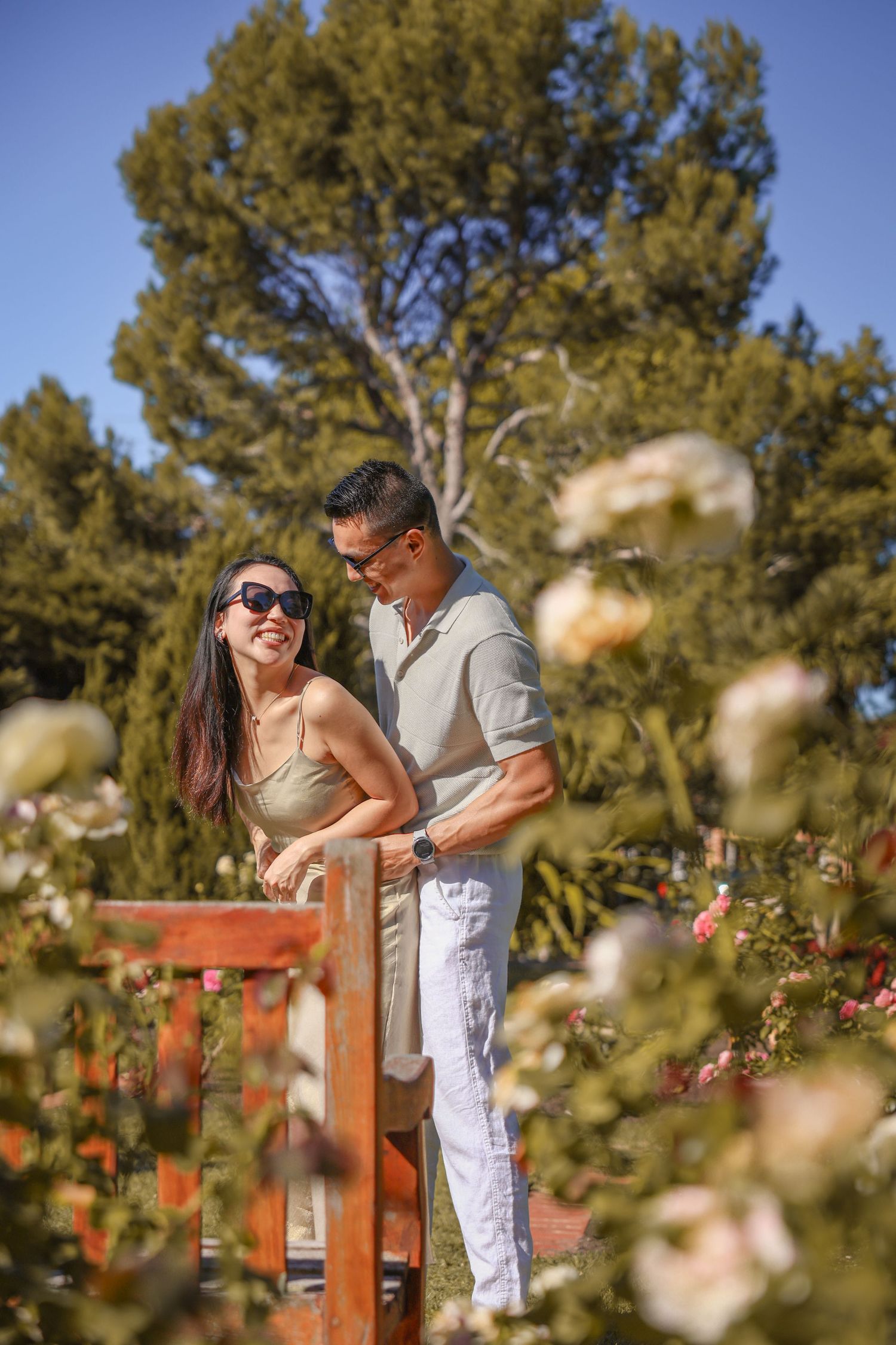 Joyful moment shared on a garden deck surrounded by blossoming flowers and trees.