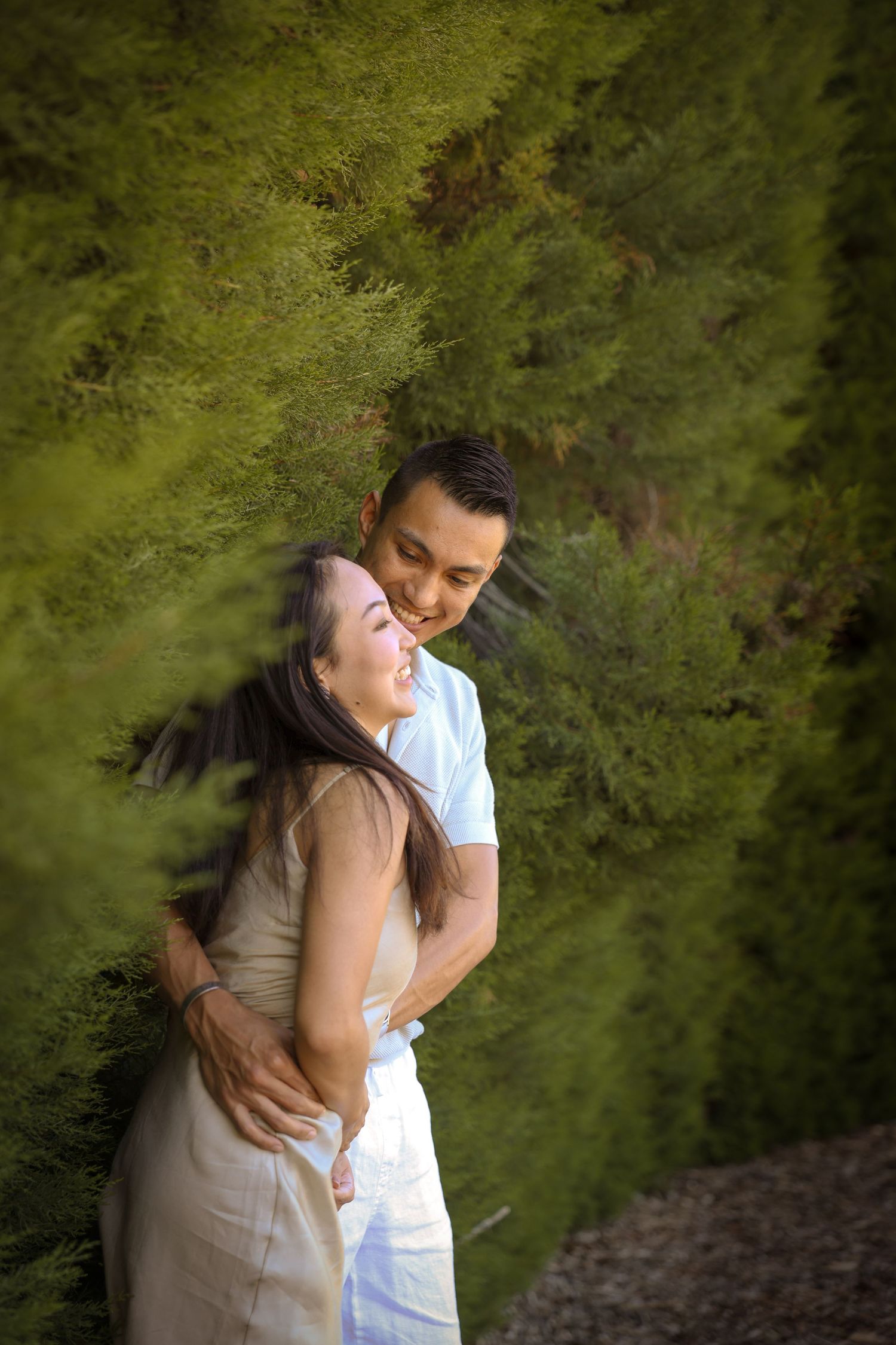 Joyful embrace captured against verdant green backdrop in natural outdoor setting.