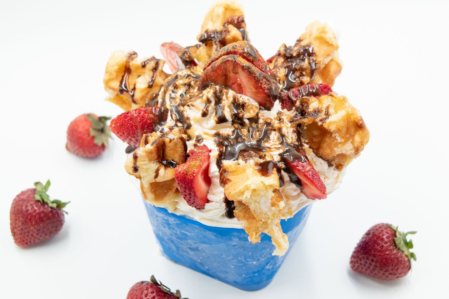 Angled shot of a strawberry chocolate waffle ice cream dessert in a professional light box