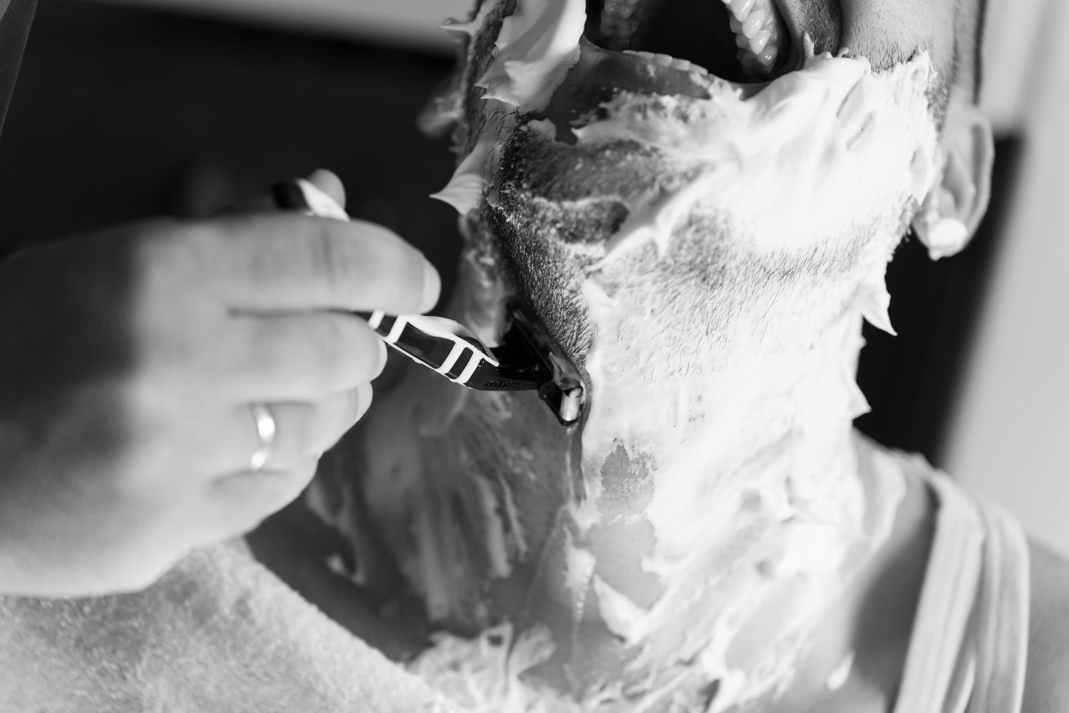 A close-up black and white image of a delicate lace veil with intricate floral patterns.