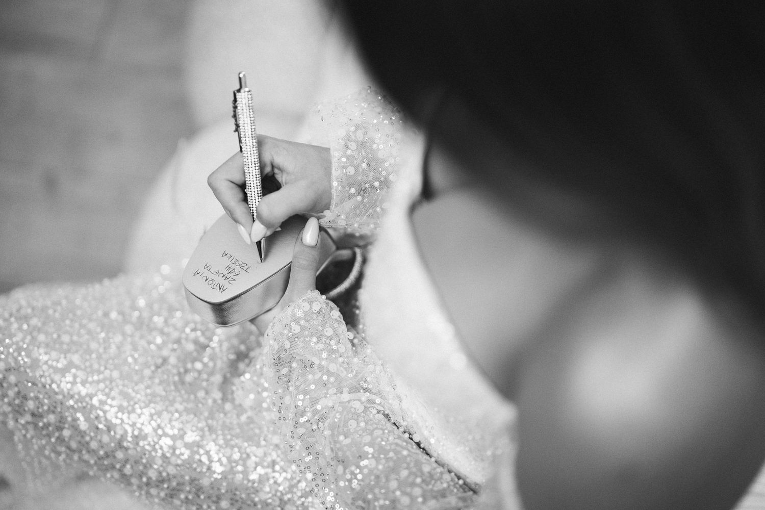 Close-up view of a sparkling white wedding dress fabric with delicate beading details.
