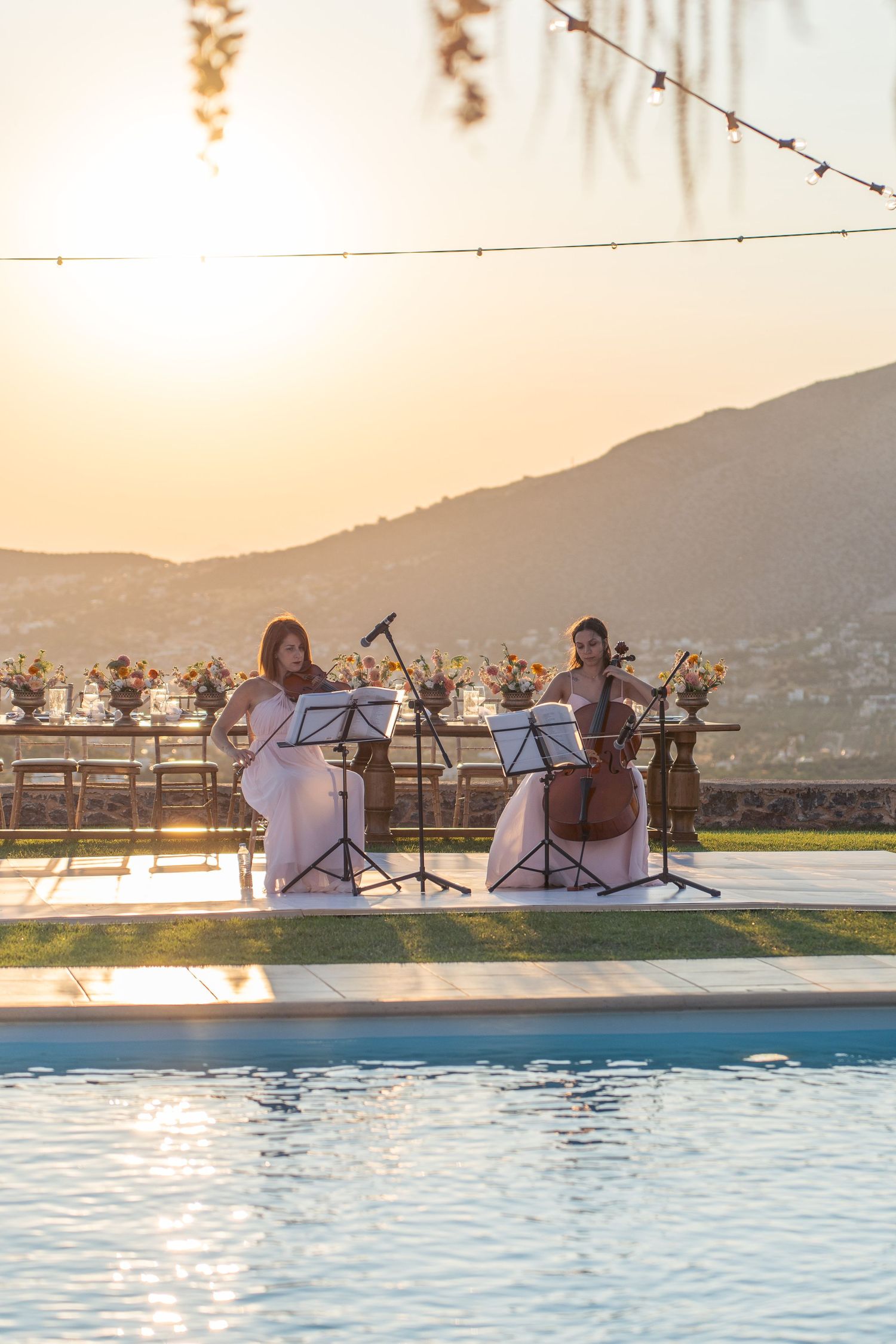 Musicians performing by a pool during sunset at an outdoor event. φωτογράφος βάπτισης Χαλκίδα