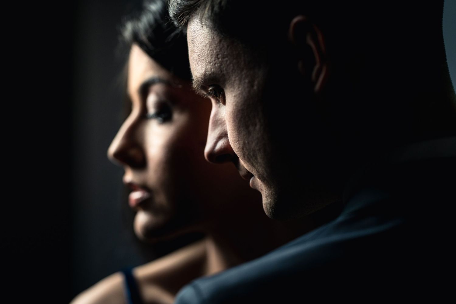 Dramatic side-lit portrait showcasing intimate connection between couple. φωτογραφος πορτραίτων