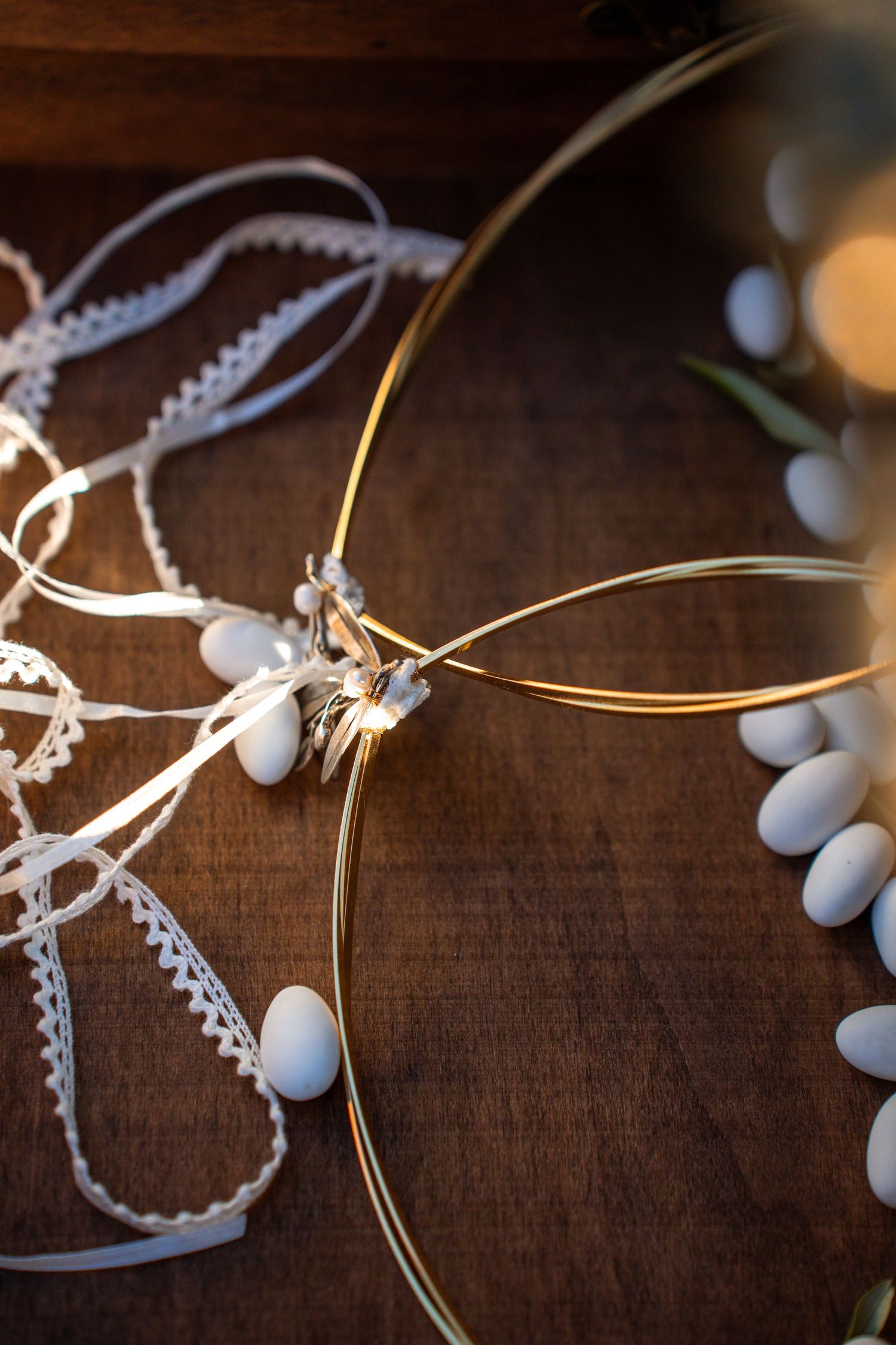 Delicate white wedding favors with lace and ribbon details on wooden surface. Φωτογραφία γάμου ελλάδα.
