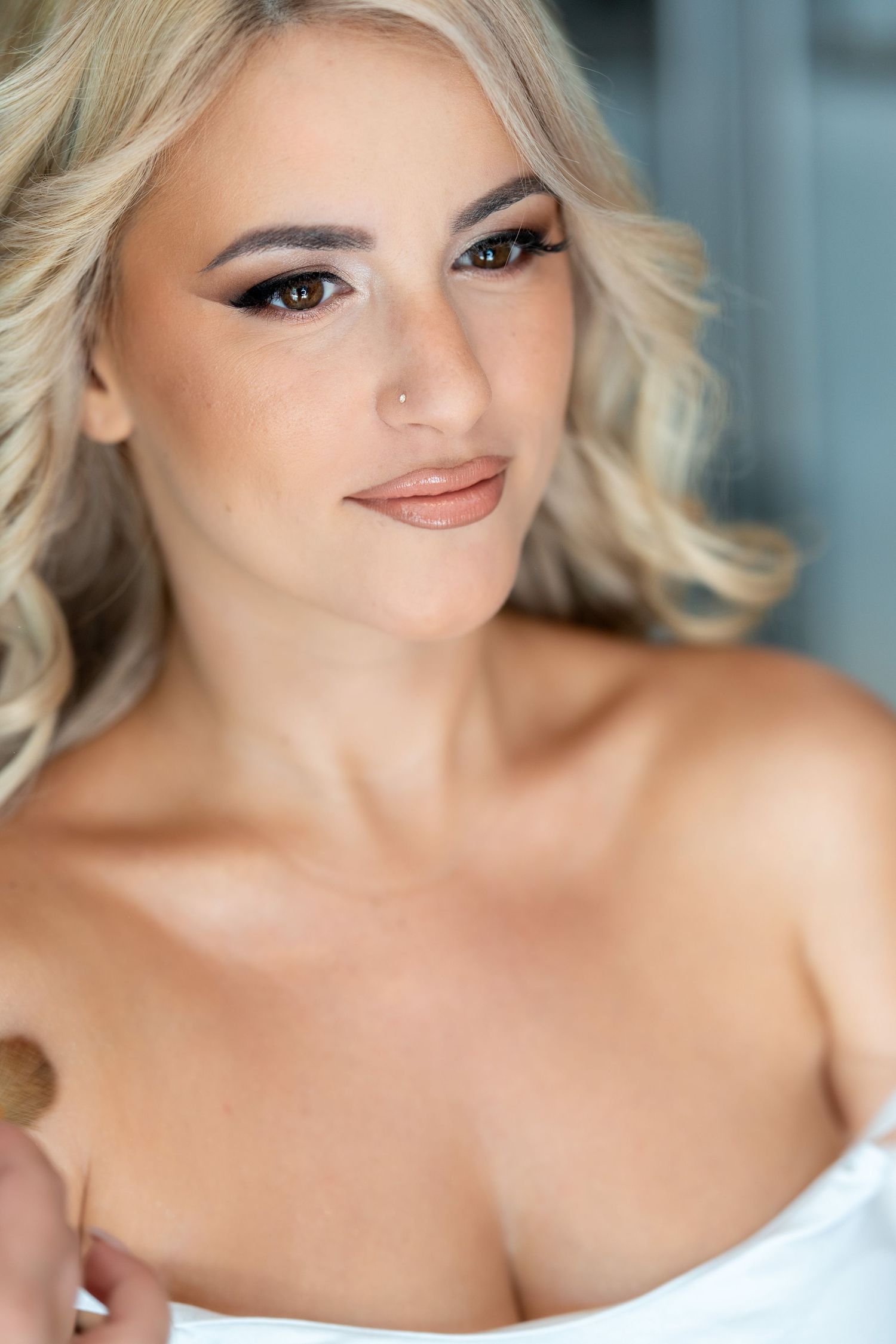 Close-up beauty portrait featuring platinum blonde hair and glamorous evening makeup in soft lighting.