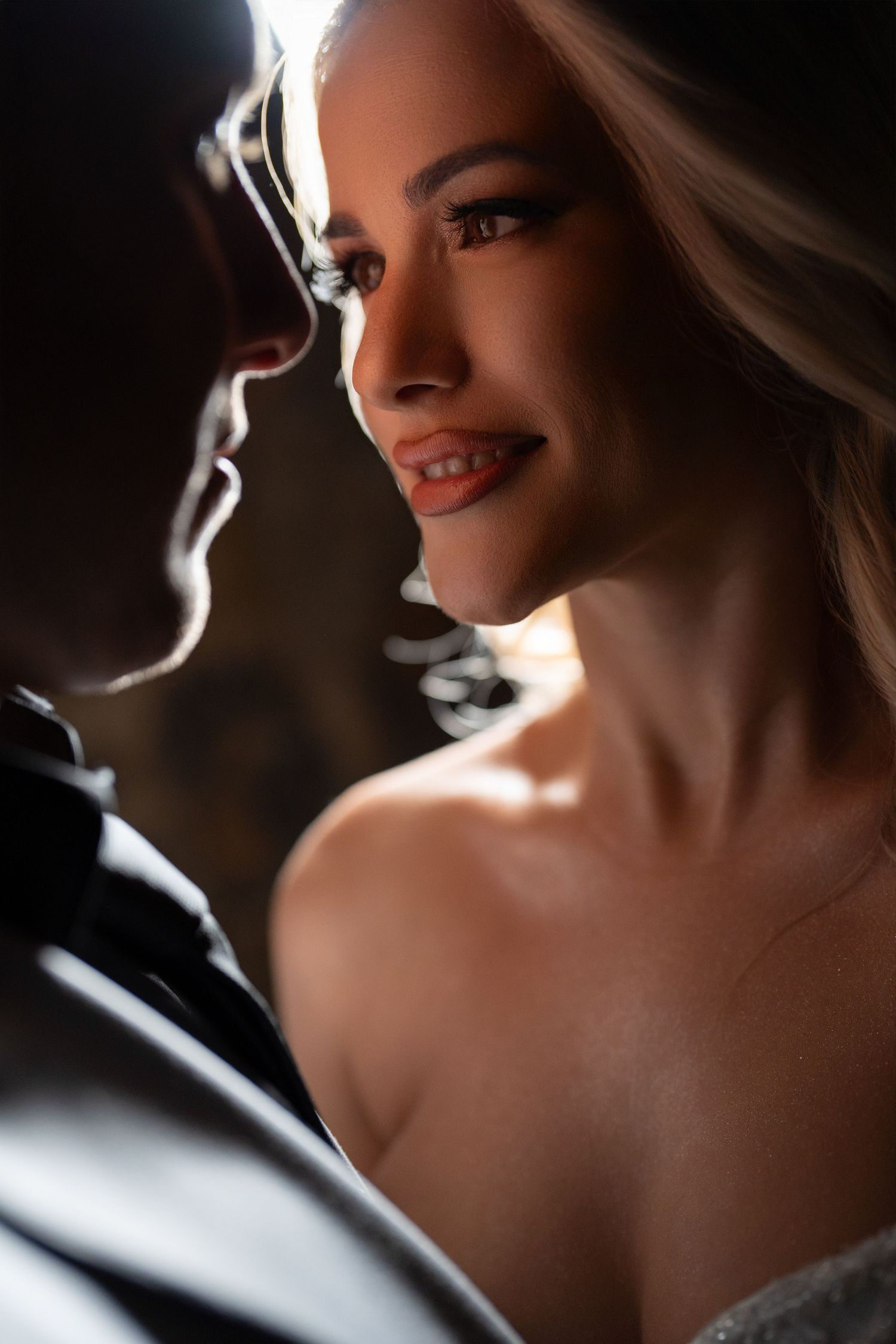 Dramatic close-up portraits of a bride with soft lighting and shadows creating a romantic atmosphere.