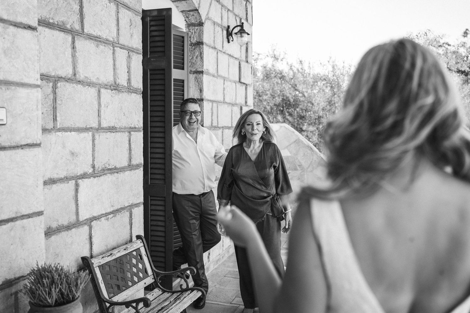 A series of candid black and white photos taken against a stone wall background.