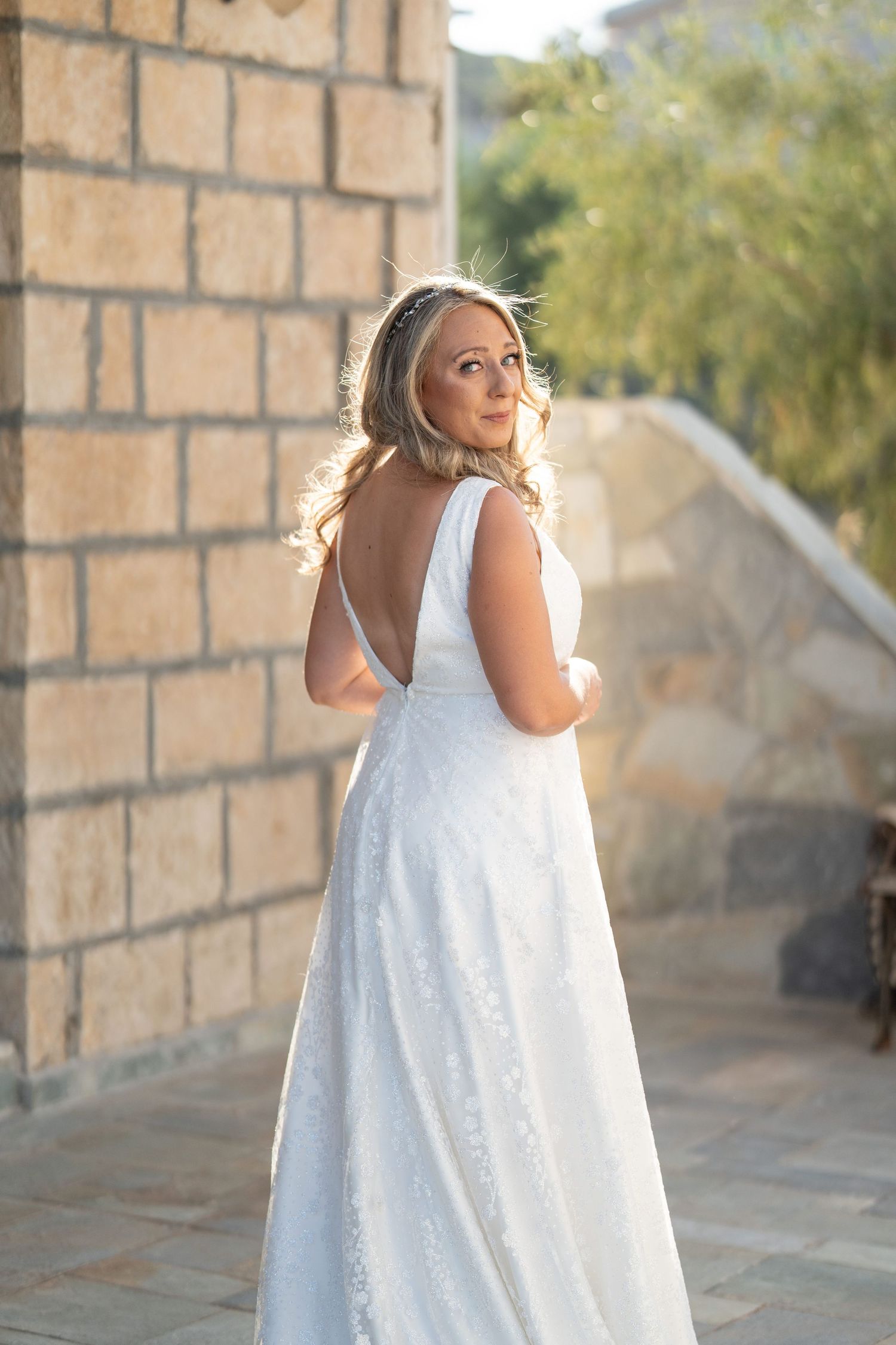 A sequence showing a person in a flowing white dress twirling against a brick wall outdoors.