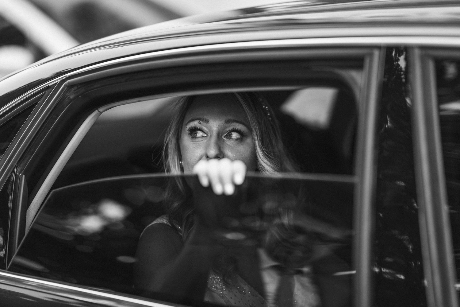 Elegant black and white photo series of a bride and groom in and around a luxury car.