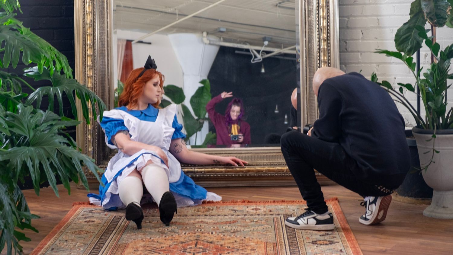 Behind-the-scenes photo of a photographer taking pictures of someone dressed in a blue and white character costume.