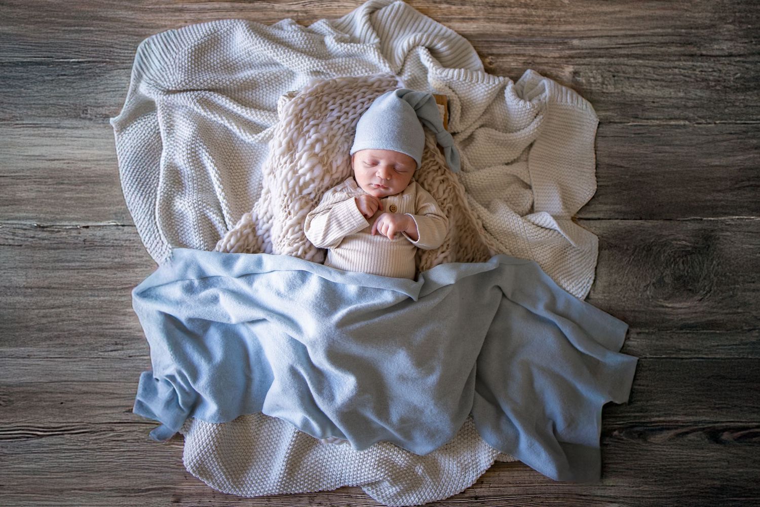 Springfield, IL Newborn Photographer captures baby laying in a basket with blankets and swaddle during a lifestyle newborn session