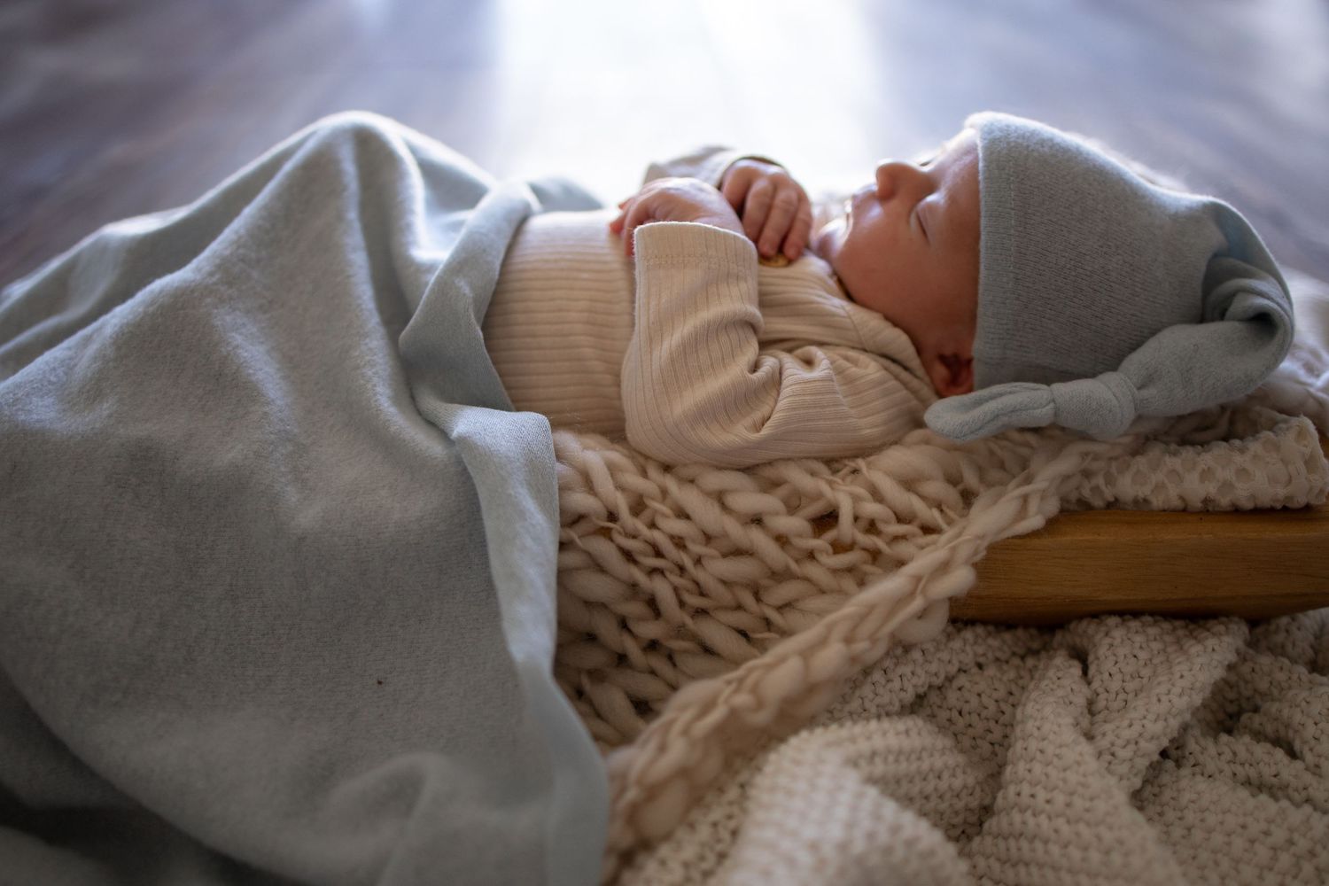 Springfield IL Newborn Photographer captures a newborn's side profile while laying in a prop during a lifestyle newborn session