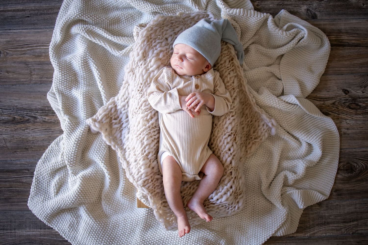 Springfield Il Newborn Photographer captures a newborn sleeping in a prop and blankets during a lifestyle newborn session in Springfield, IL