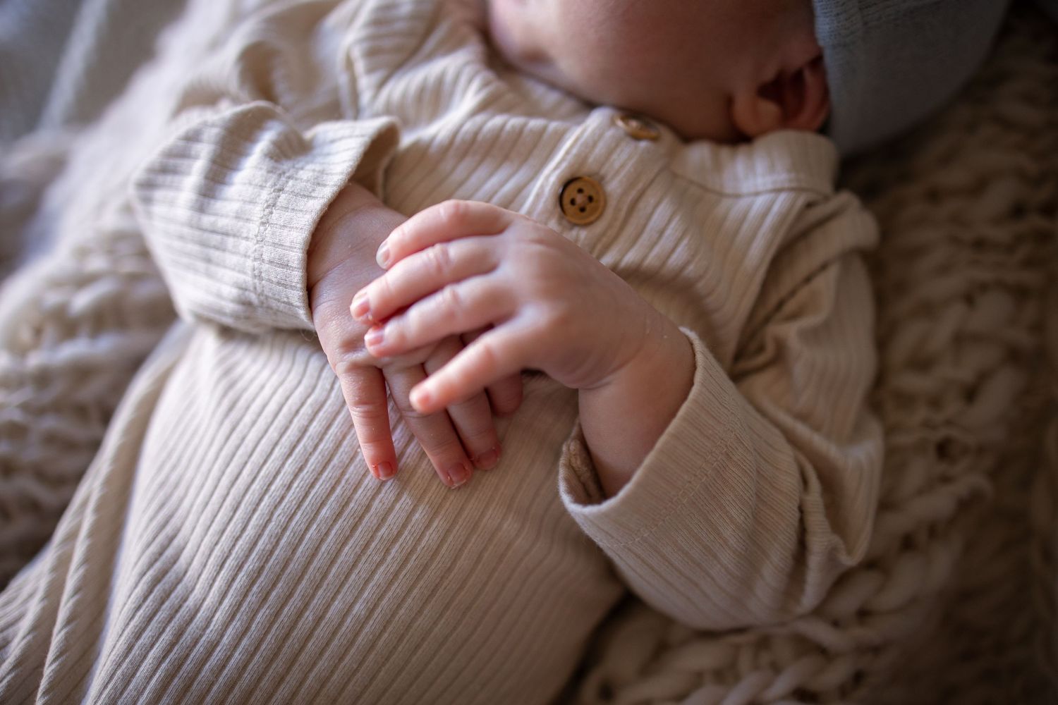 Springfield, IL Newborn Photographer captures a close up of a newborn's hands folded during a lifestyle newborn session in Central, IL
