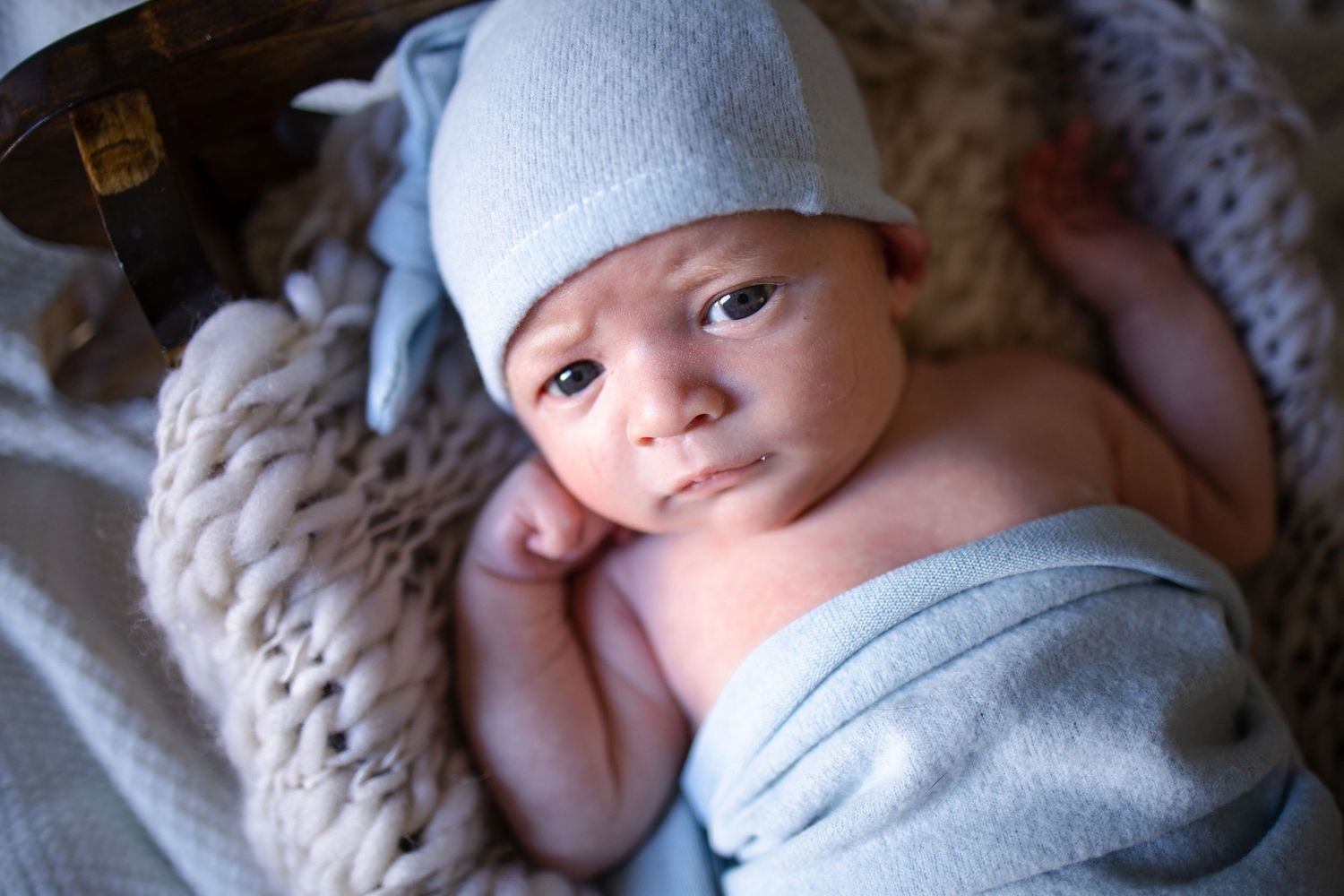Springfield IL Newborn Photographer captures a newborn swaddled looking at the camera during a lifestyle newborn session