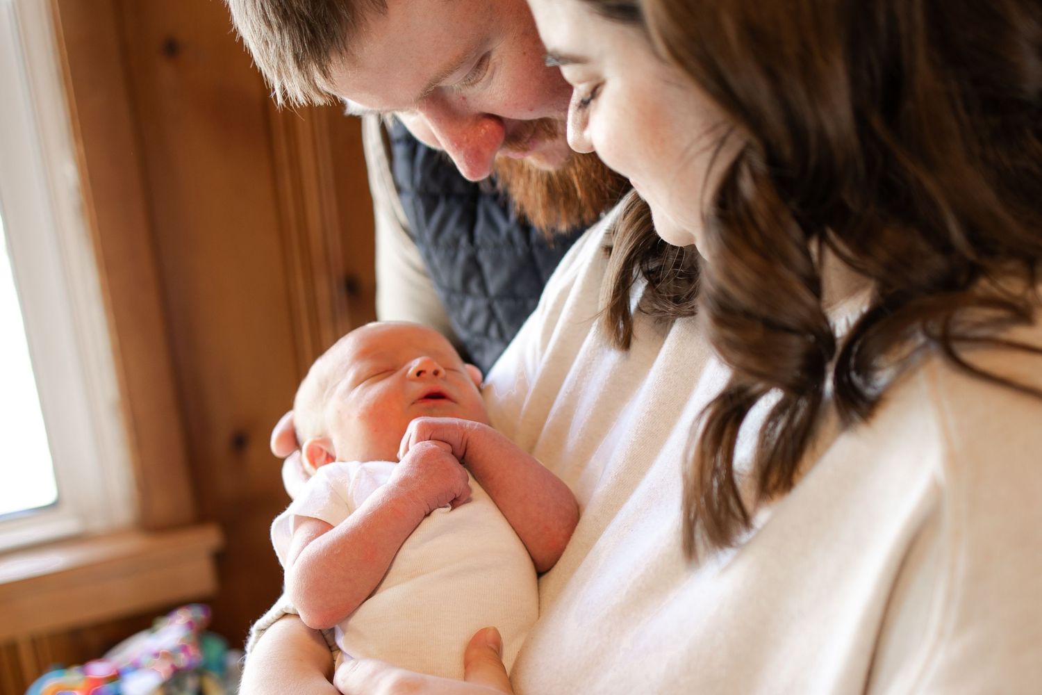 Springfield, IL Newborn Photographer captures mom and dad looking at their newborn during a lifestyle newborn session in Central IL