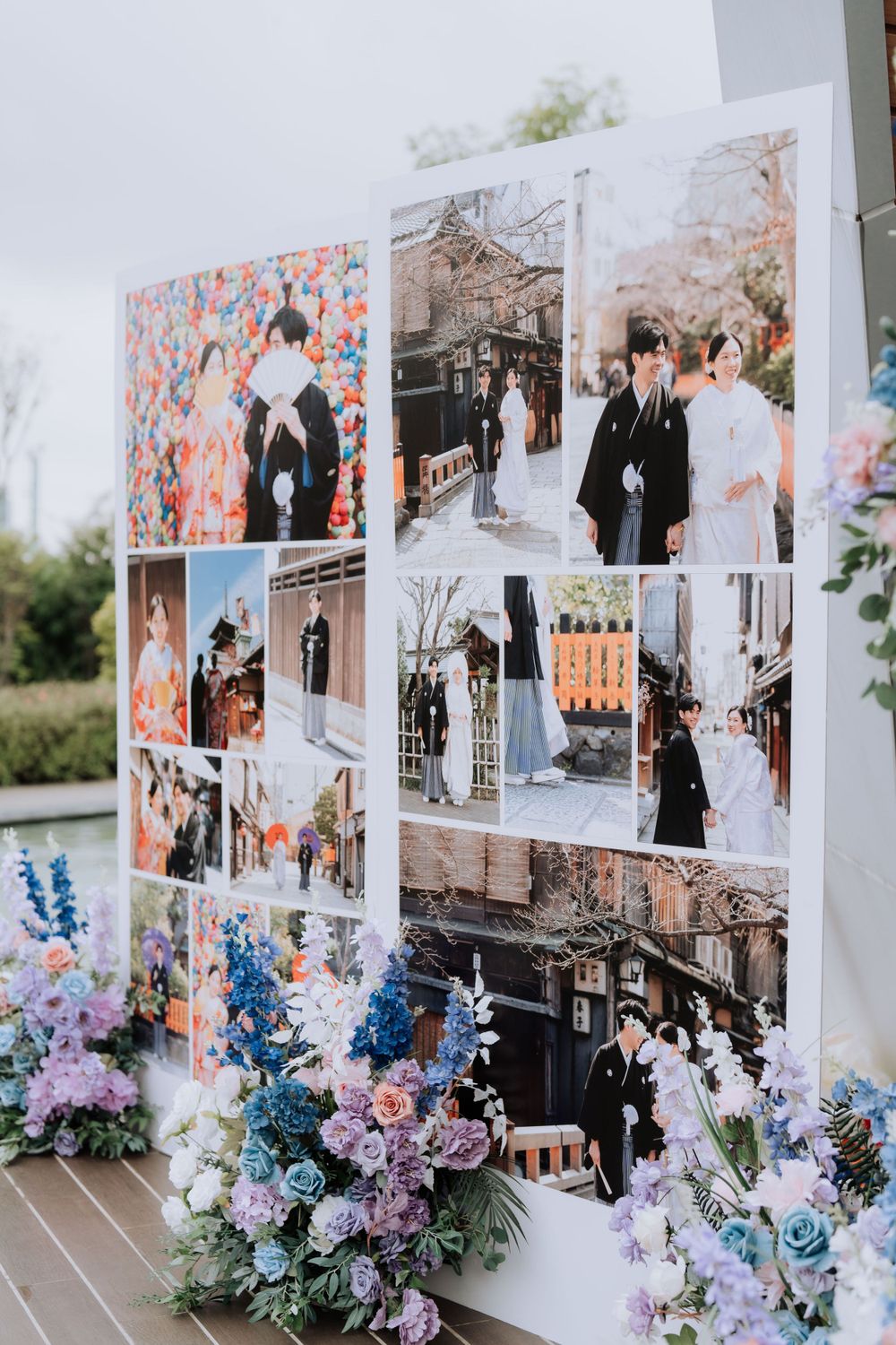 A wedding photo display board decorated with blue and purple flowers showing various ceremony and couple portraits.