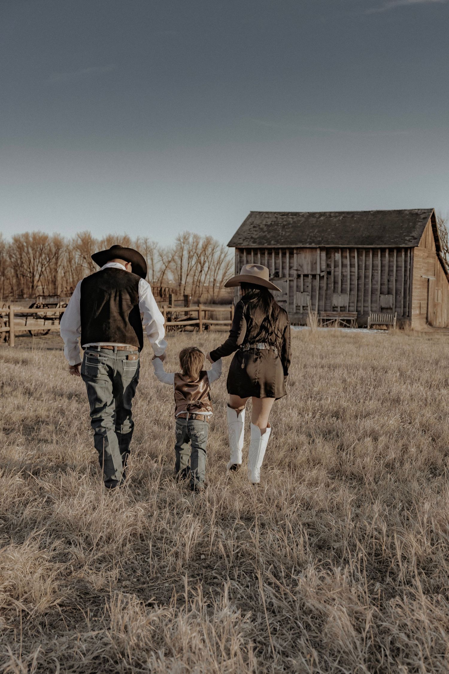 Family with a little kid walking away from camera
