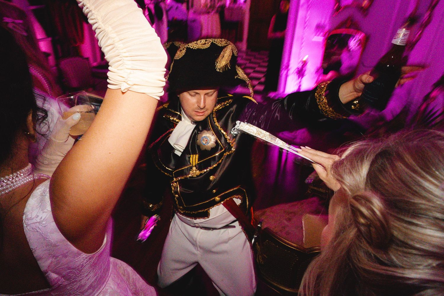 Person dressed as Napoleon Bonaparte posing dramatically at a themed costume party.