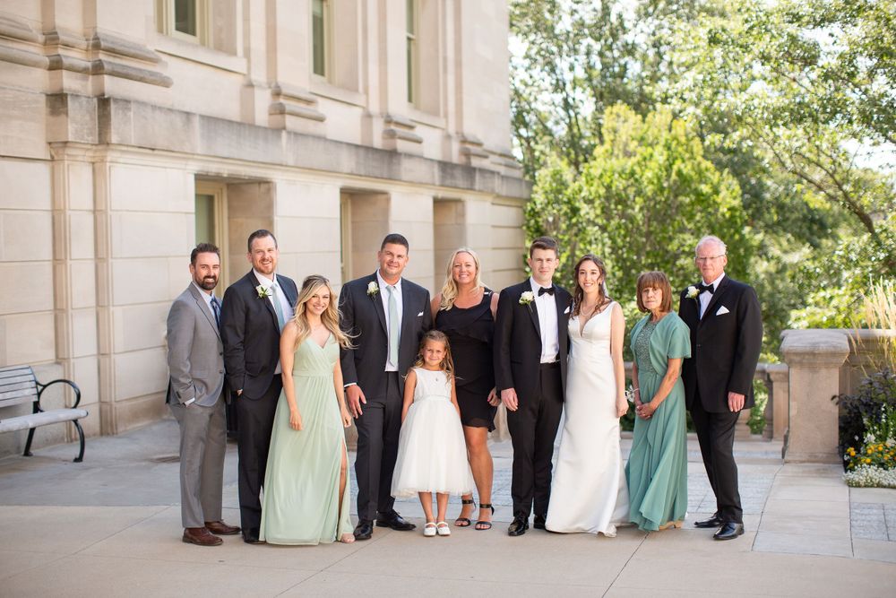 Wedding party stands elegantly on stone stairs wearing mint green and formal attire.  Iowa City wedding photographer.