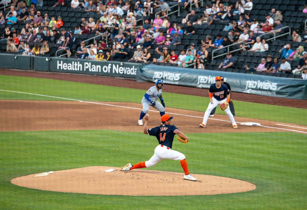 Minor league baseball pitcher winds up on mound during game at Health Plan of Nevada stadium.