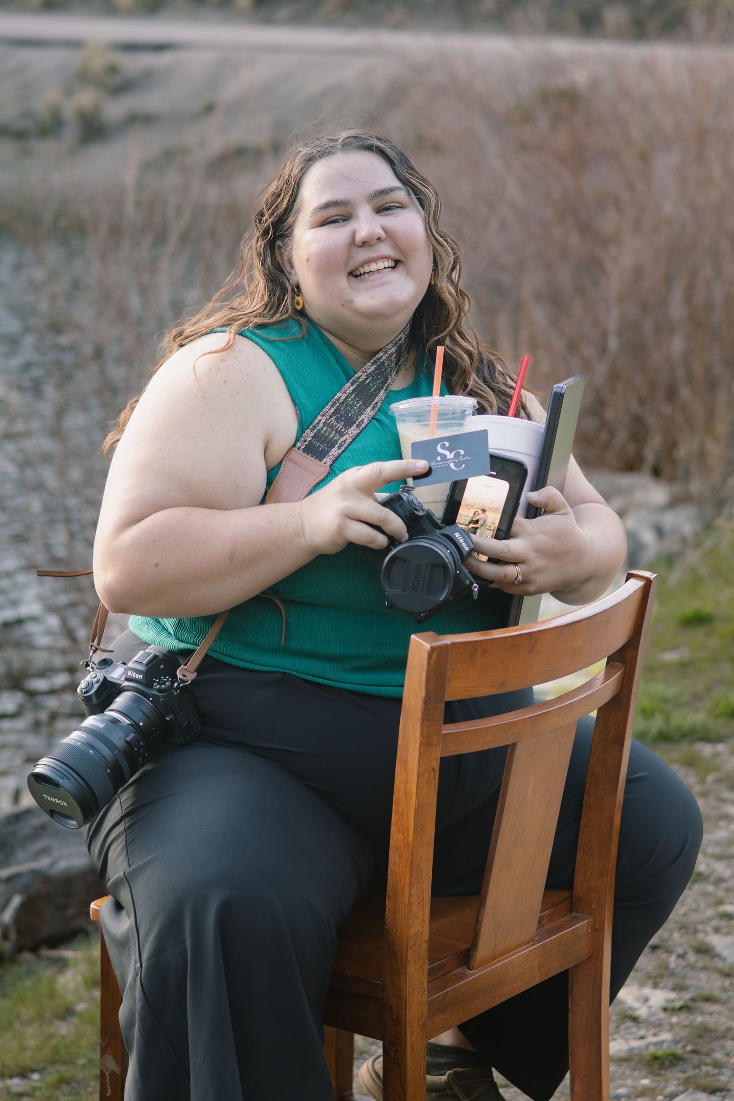 Behind-the-scenes branding image of a photographer sitting with gear and drinks.