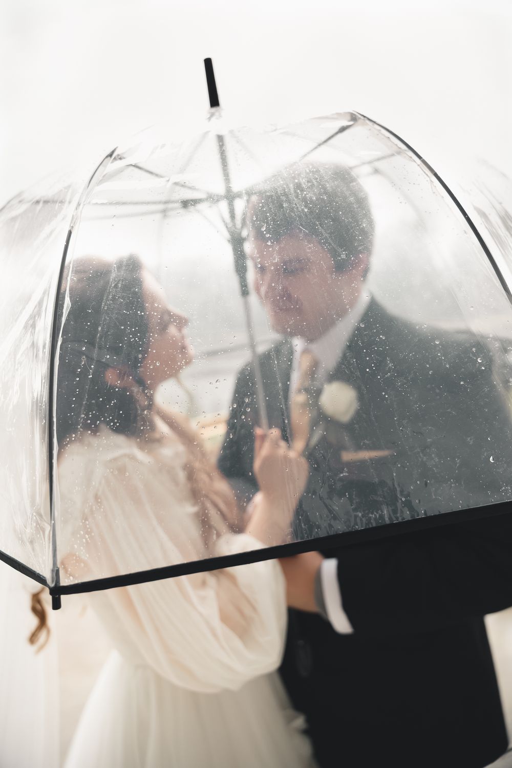 Romantic rainy day wedding at Buhl Park in Hermitage, Pennsylvania. Timeless, candid photography capturing love under a clear umbrella.