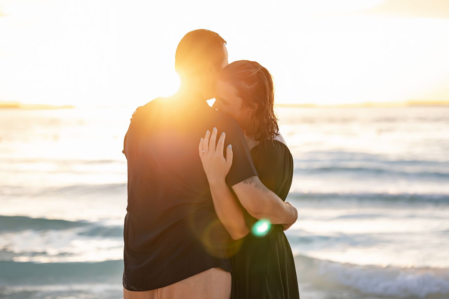 Romantic sunset embrace during Alexia and Scott’s engagement session on the beach in Isla Mujeres, Mexico.