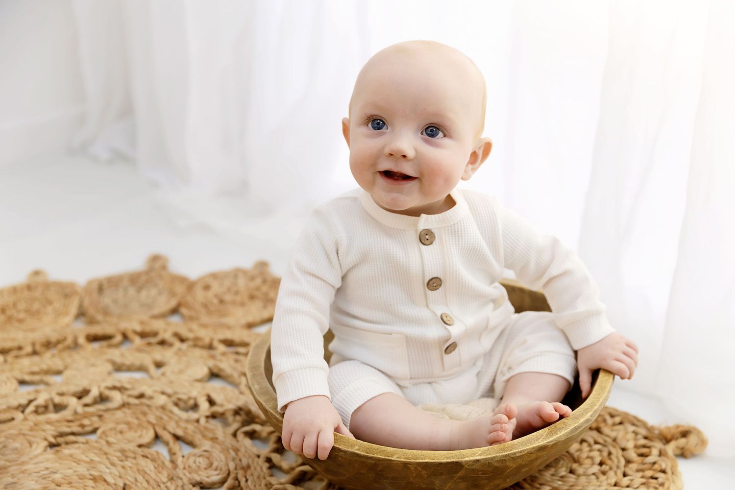 Little boy sitting in a bowl smiling at his sitter session in Coventry with Shelly Loxton Photography