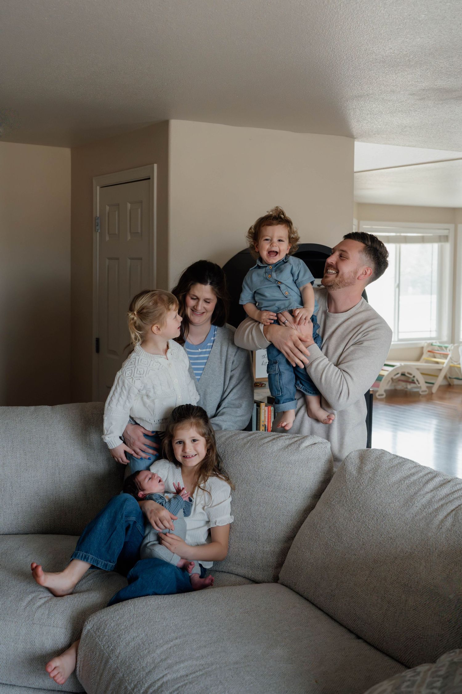 Natural in-home family portrait with parents, newborn, toddler, and young children during Spokane family photography session.