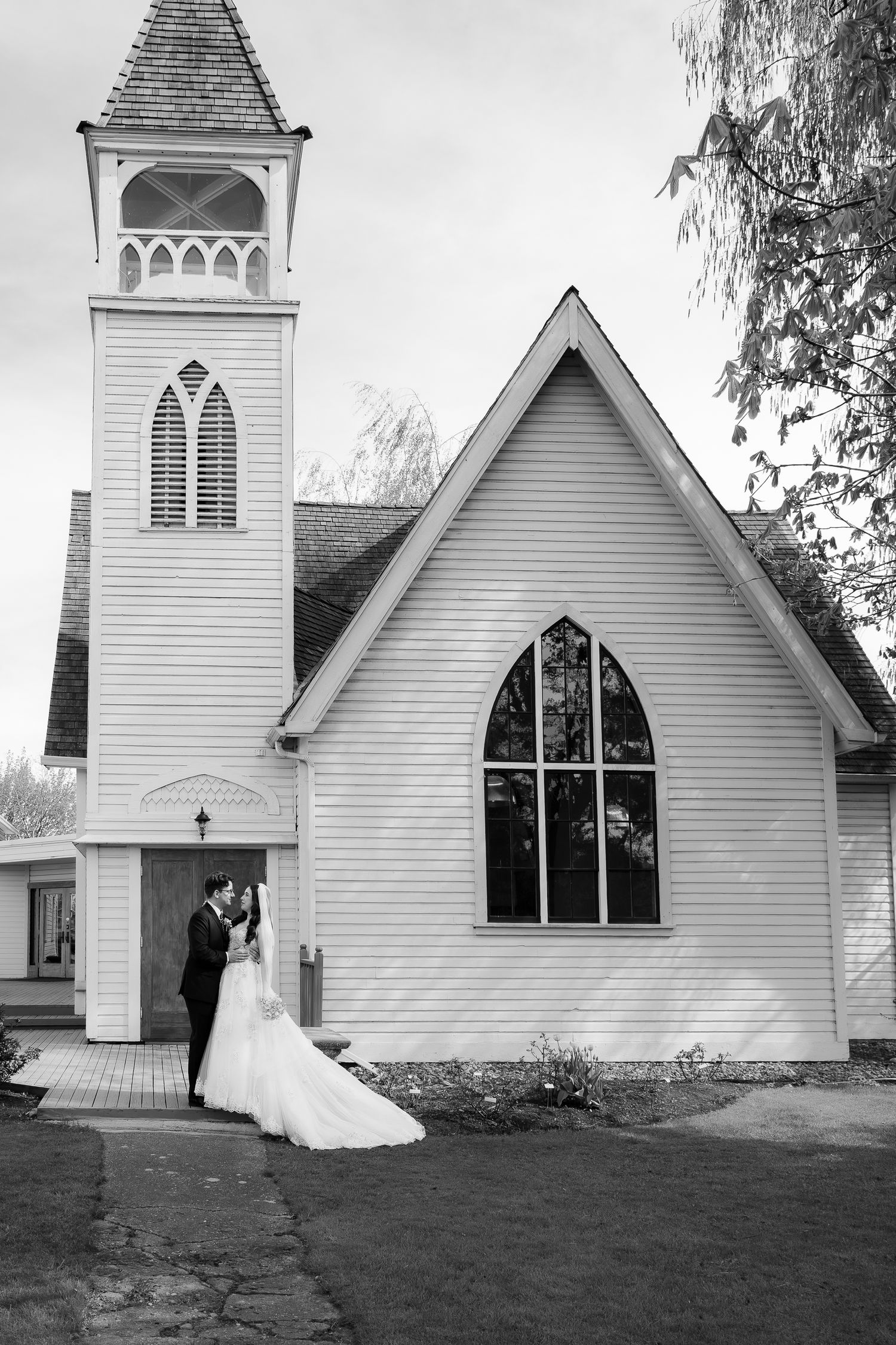 Black and white wedding outside a rustic church