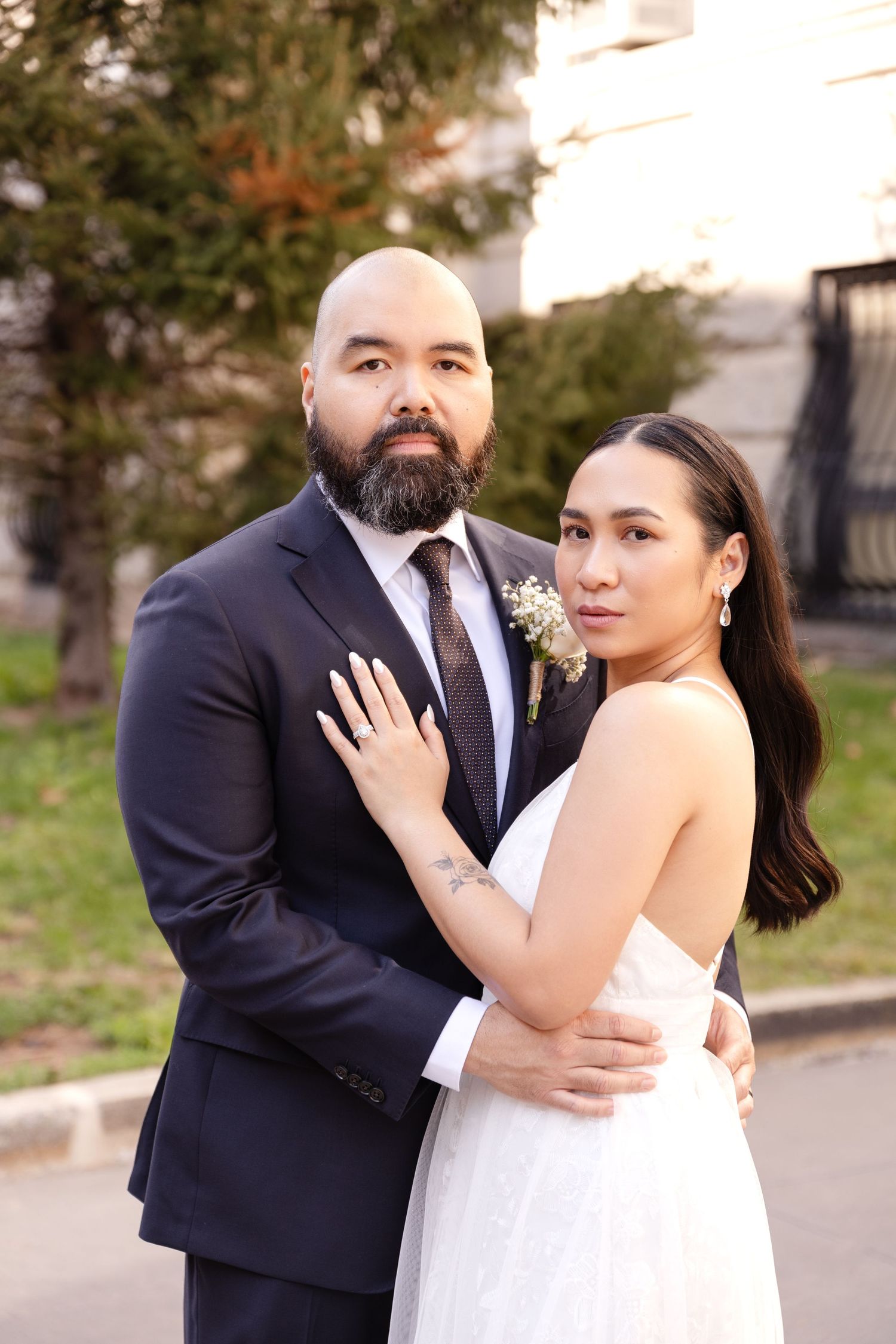 Intimate black and white portrait of couple embracing in elegant wedding attire.