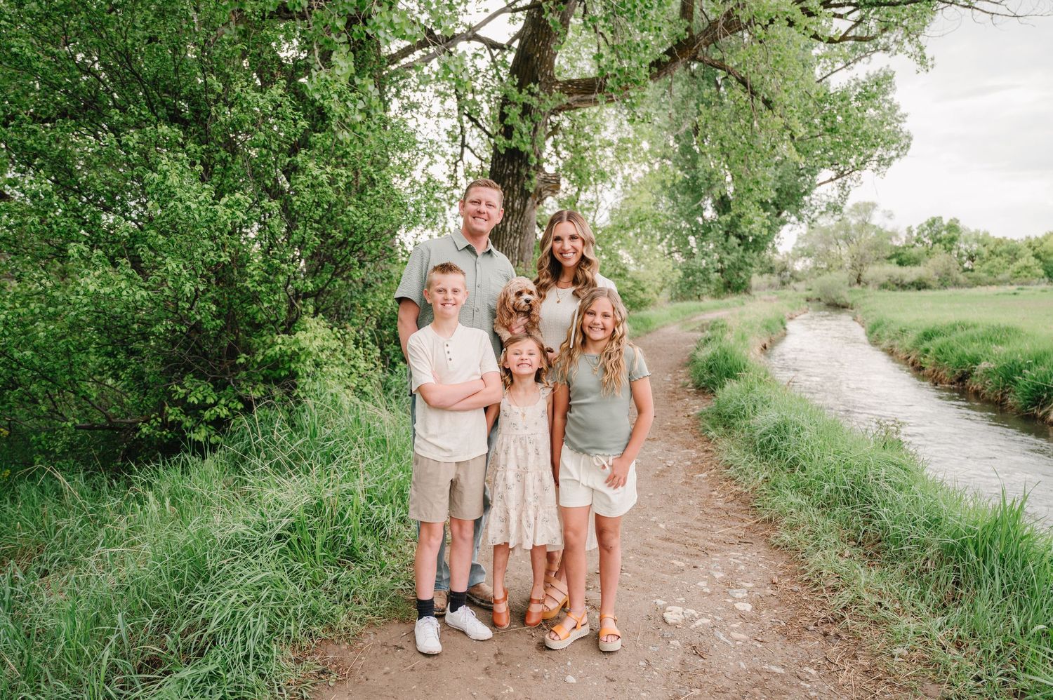 Group enjoying a casual stroll together on a dirt path surrounded by lush green trees and vegetation.