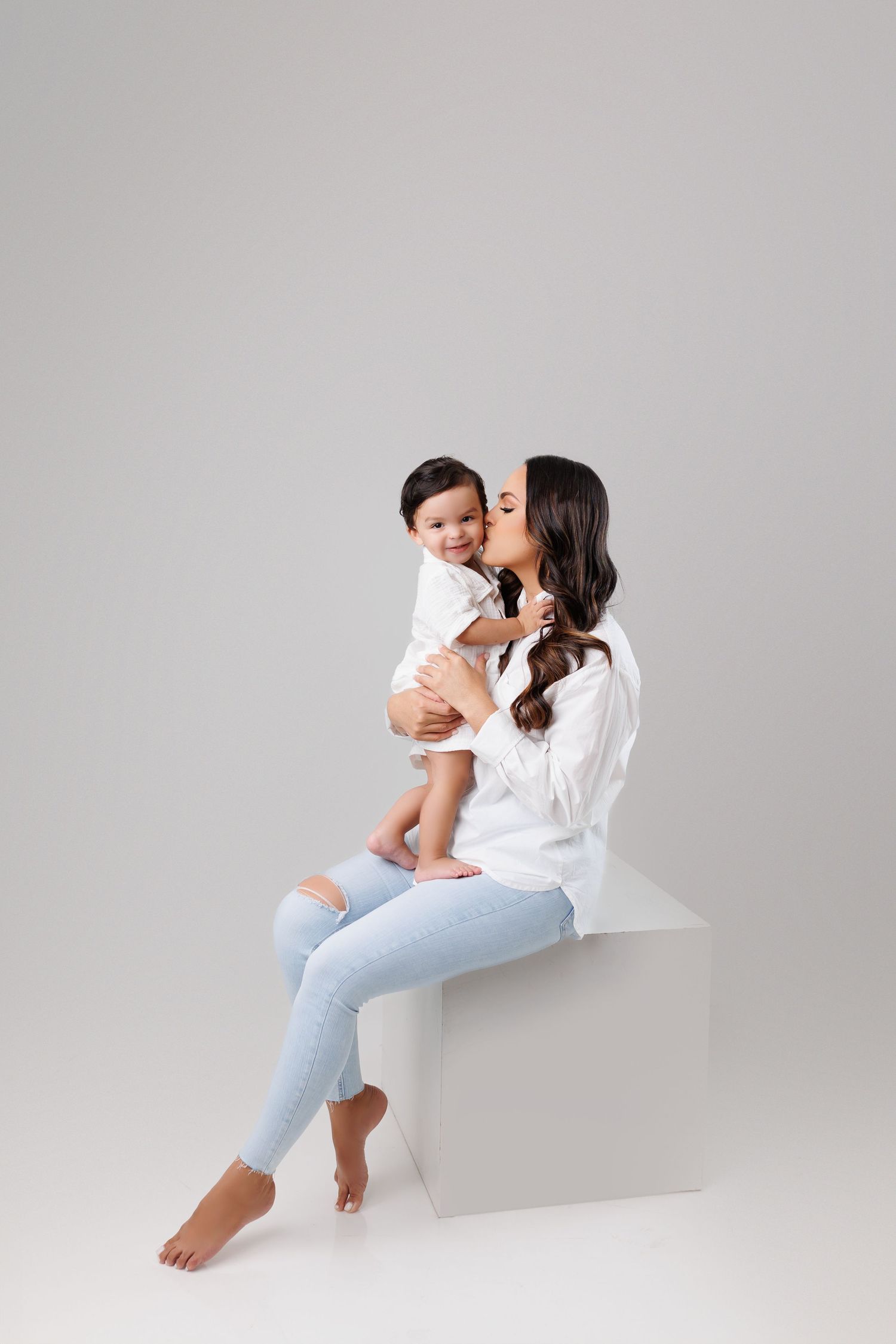 Tender mother-child portrait sequence showing affectionate moments against minimal grey background.