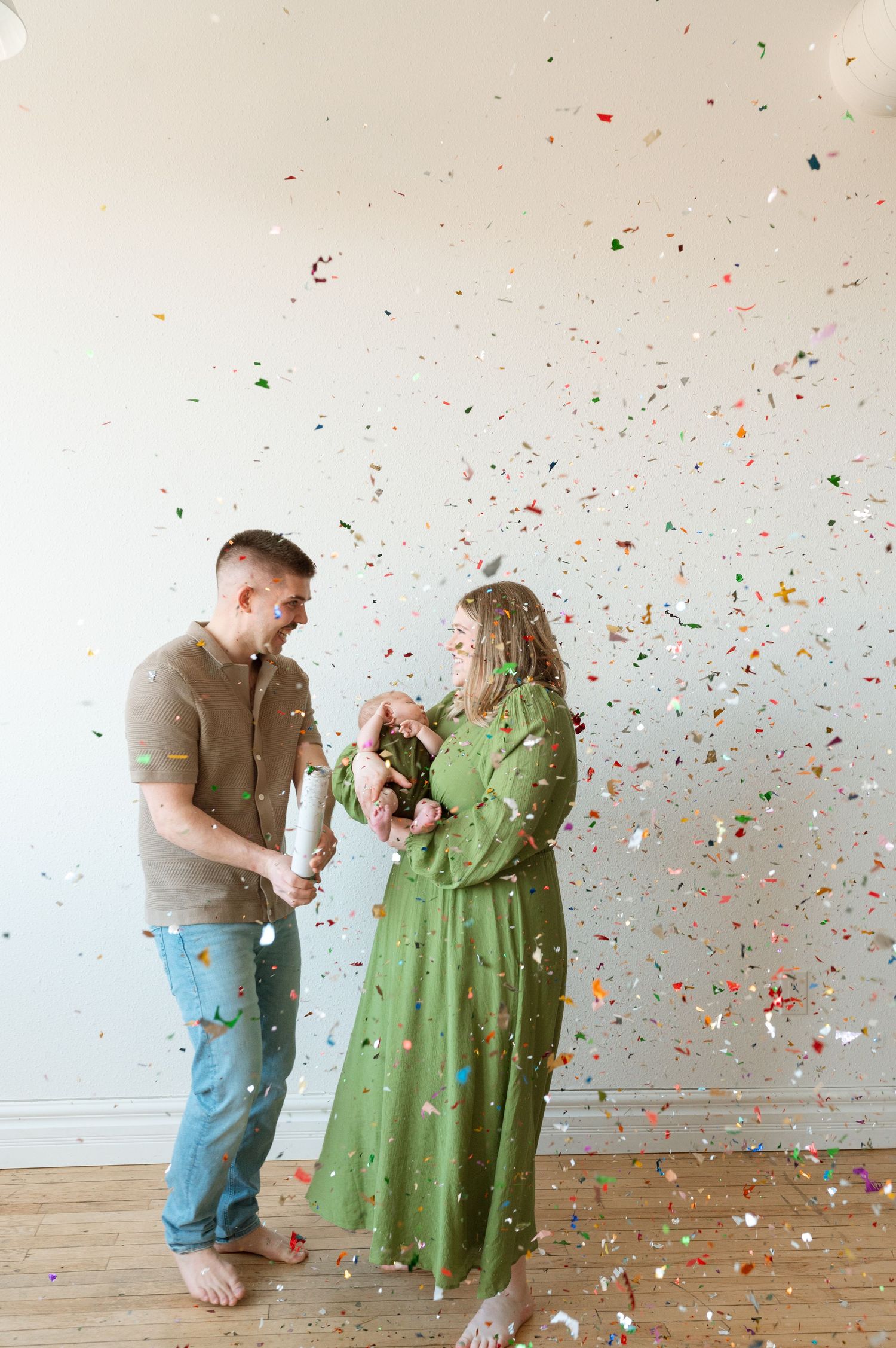 A celebration scene with confetti raining down on a couple standing together in a minimalist indoor setting with hardwood floors.