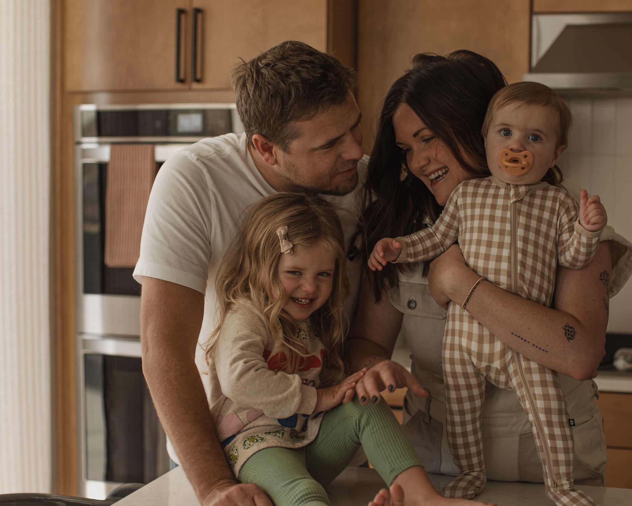 A tender family moment captured in a warm-toned interior setting with natural lighting.