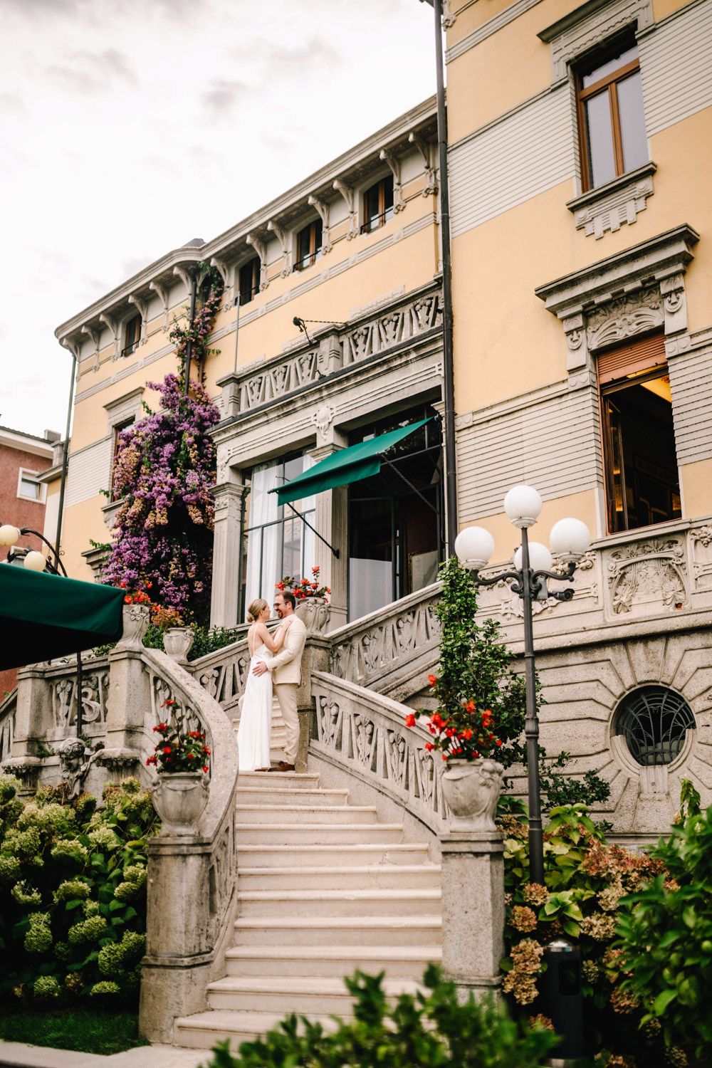 Finnish bride and groom during their romantic photo session on the stairs of a historic hotel in Lake Garda