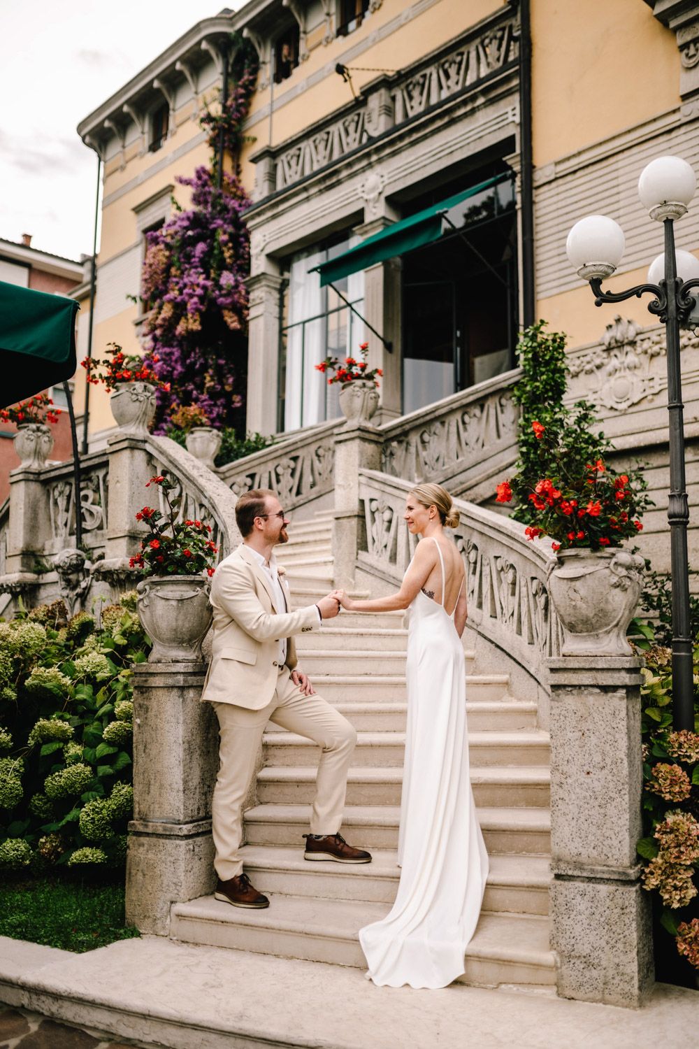 Finnish bride and groom during their romantic photo session on the stairs of a historic hotel in Lake Garda