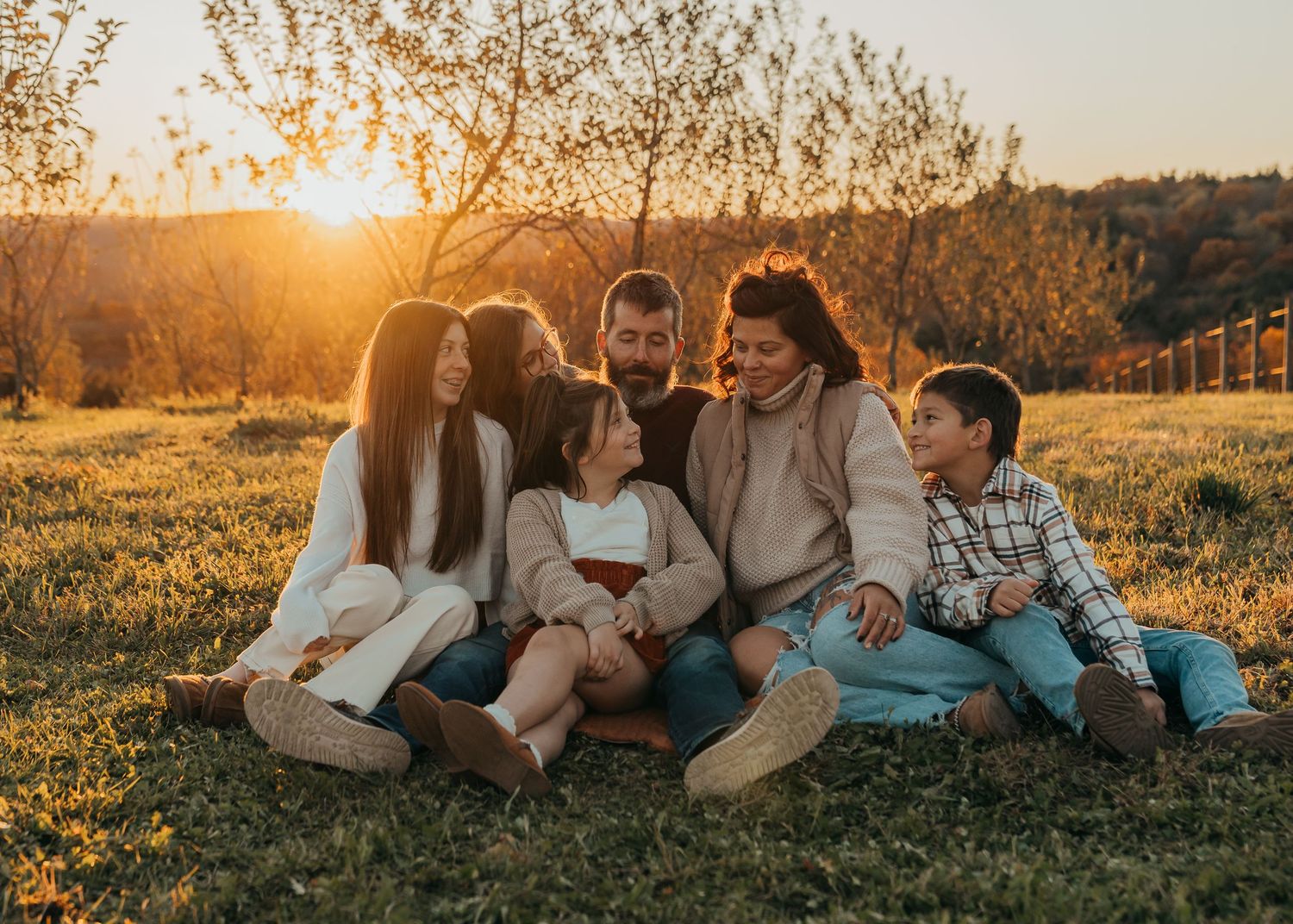 A family shares tender moments together in a rustic cabin setting with twinkling lights in the background.